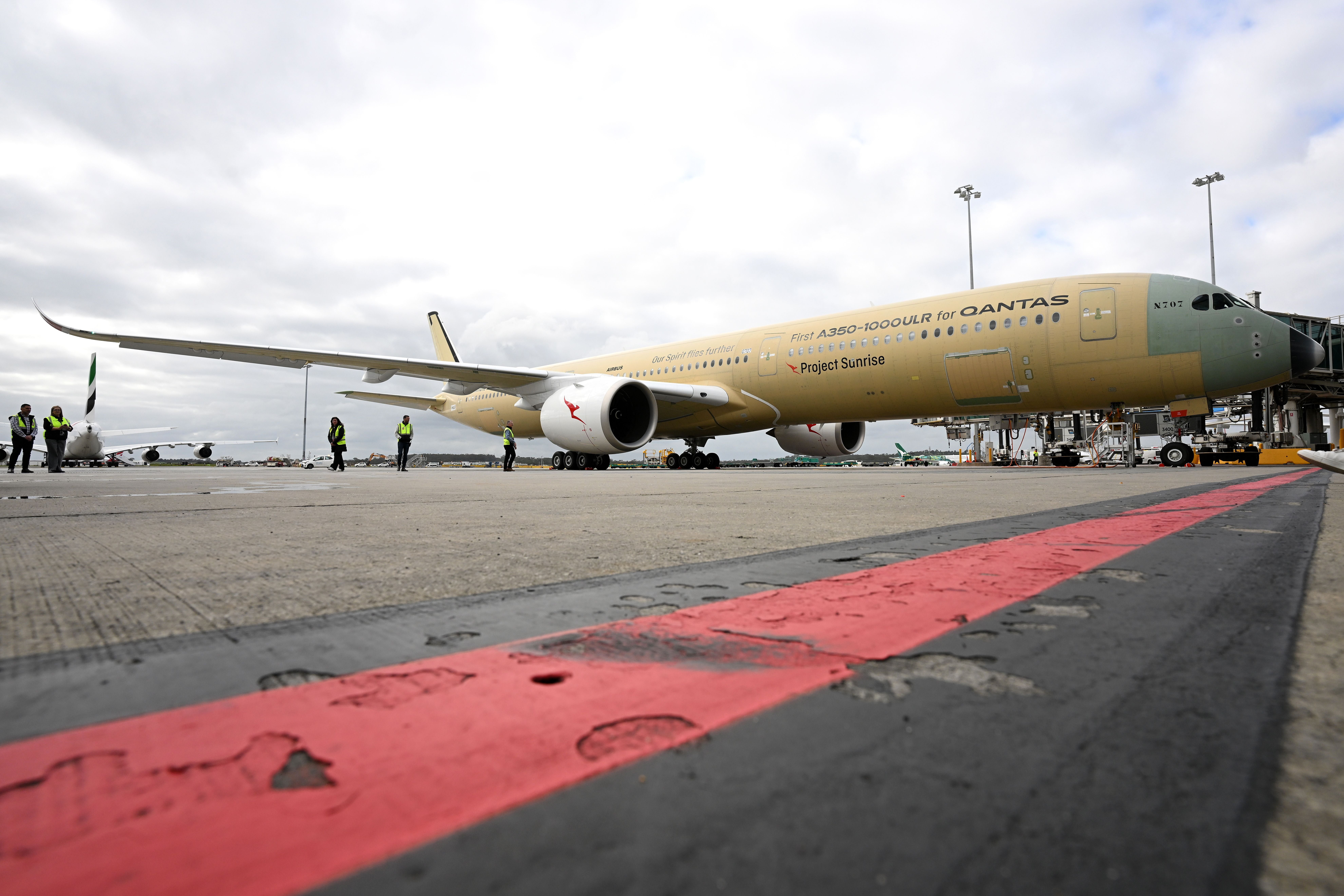 Ein Airbus A350-1000ULR für Qantas steht am Flughafen Melbourne, Personen in Warnwesten daneben.