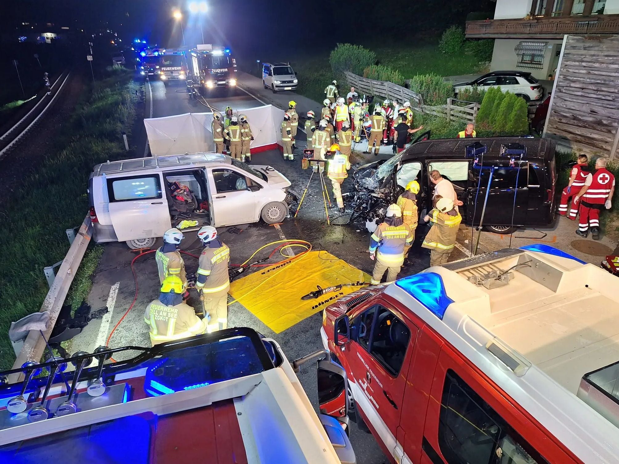 Großeinsatz von Feuerwehr und Rettung nach schwerem Verkehrsunfall mit zwei Vans bei Nacht.