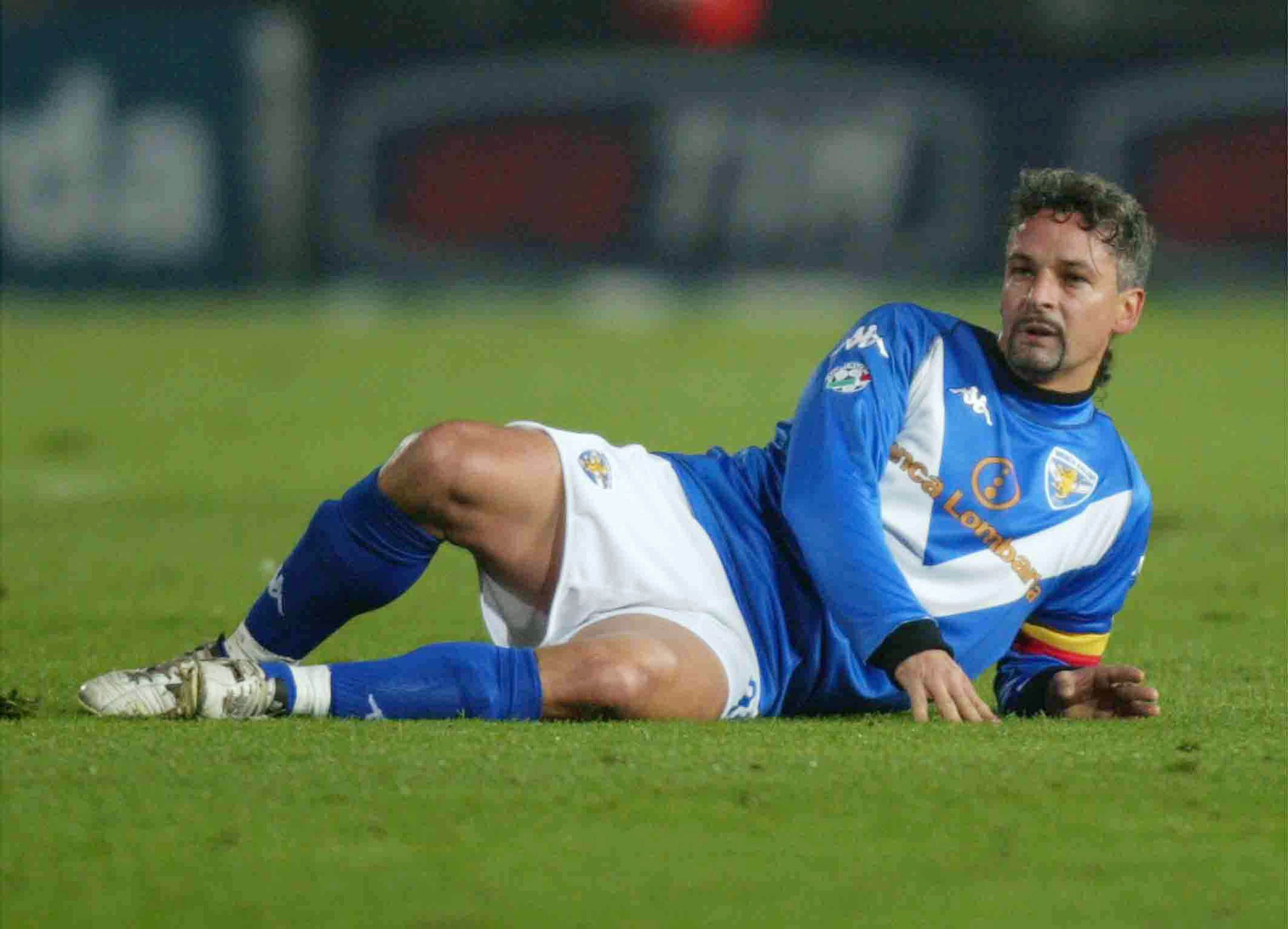 Ein Fußballspieler im blauen Trikot liegt während eines Spiels auf dem Rasen.