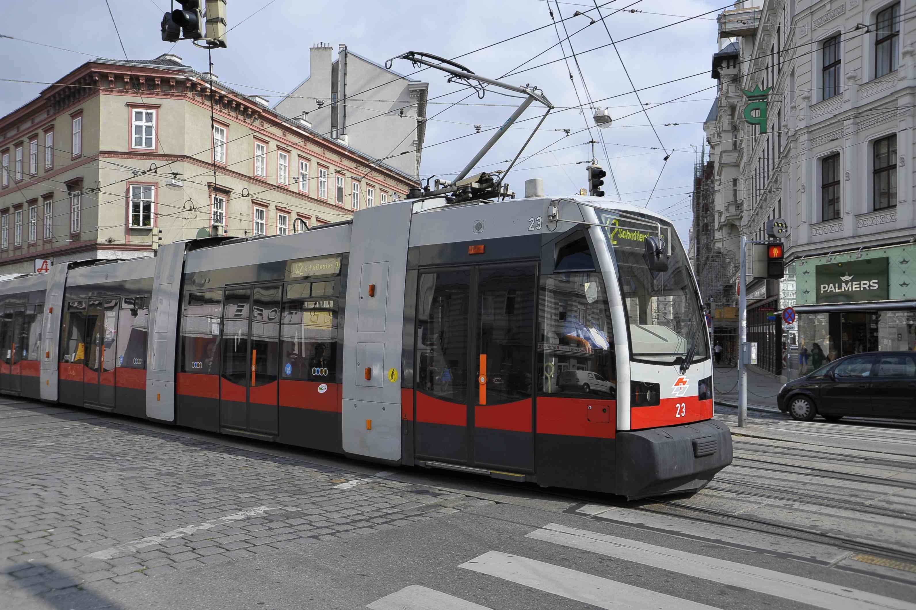 Straßenbahn der Linie 42 fährt durch eine Kreuzung in einer Stadt mit historischen Gebäuden.