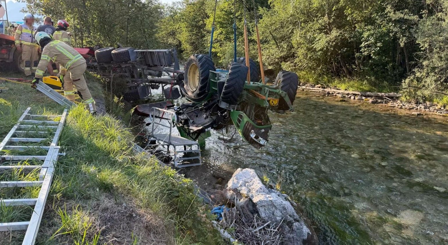 Feuerwehr hebt einen umgestürzten Traktor aus einem Bachbett bei der Tiroler Ache.