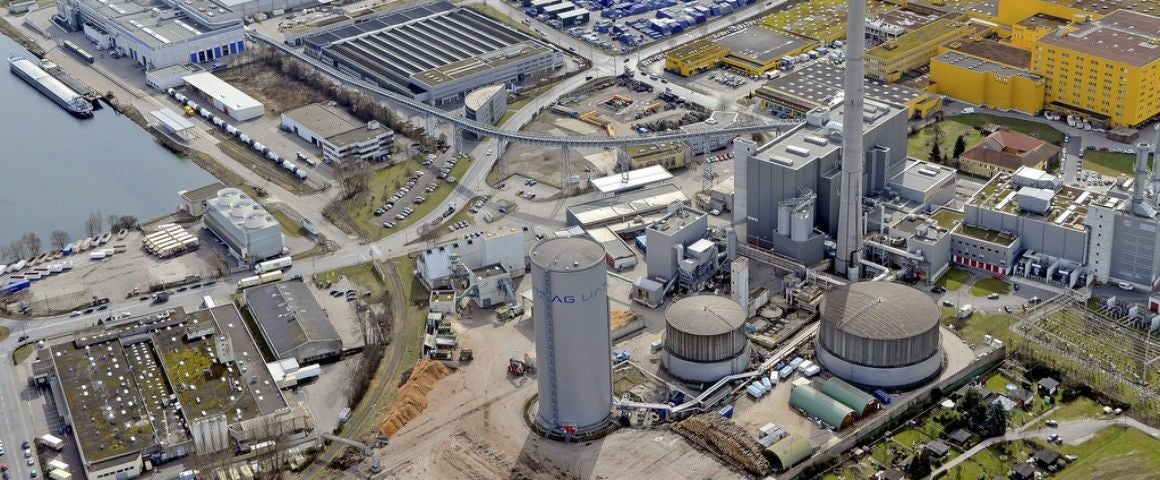 Luftaufnahme eines großen Industriekomplexes mit Kraftwerk und angrenzenden Gebäuden in Linz.