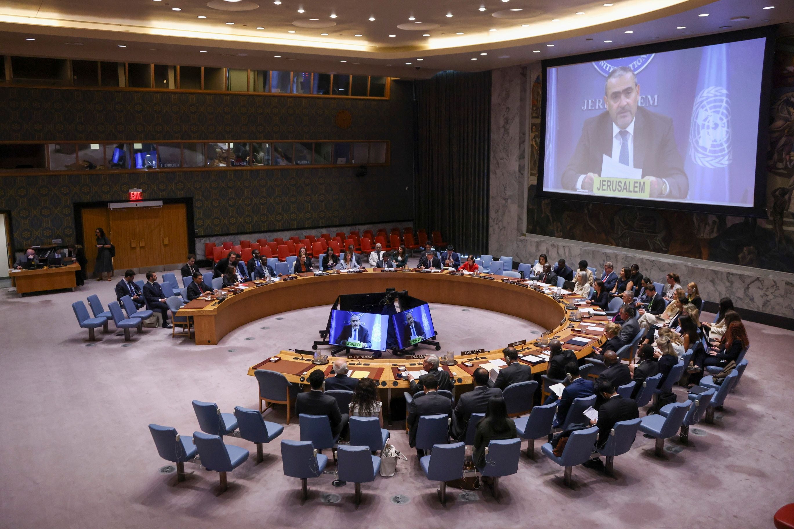 UN-Sicherheitsratssitzung in New York mit Videokonferenz auf großer Leinwand.