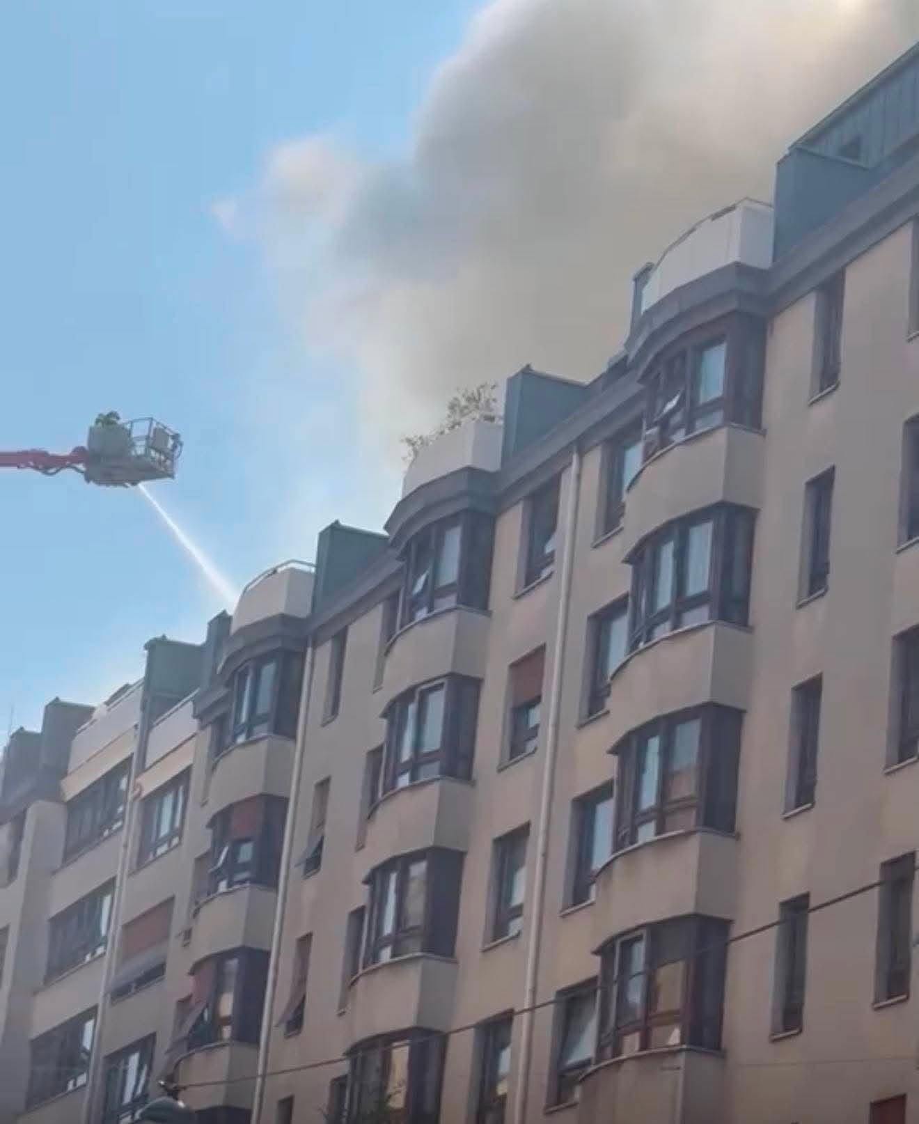 Feuerwehr löscht Dachstuhlbrand auf einem mehrstöckigen Wohnhaus in Meidling, starker Rauch steigt auf.
