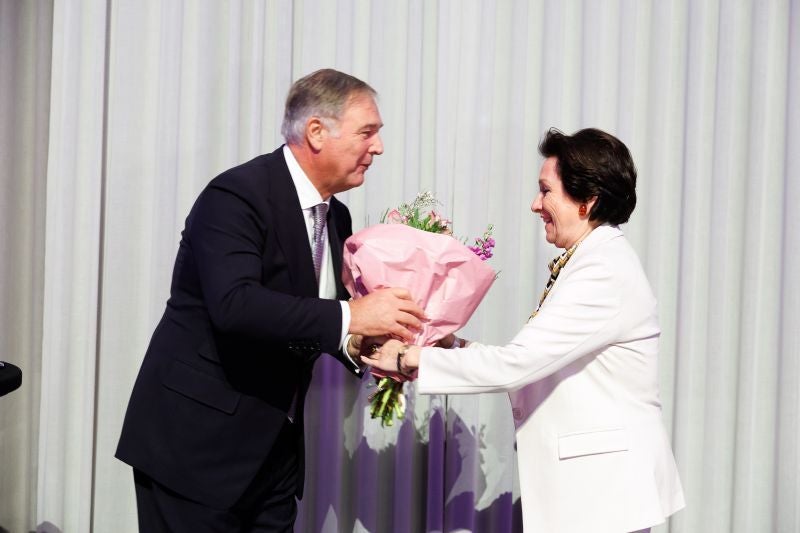 Ein Mann überreicht einer Frau einen Blumenstrauß, beide lächeln sich an.