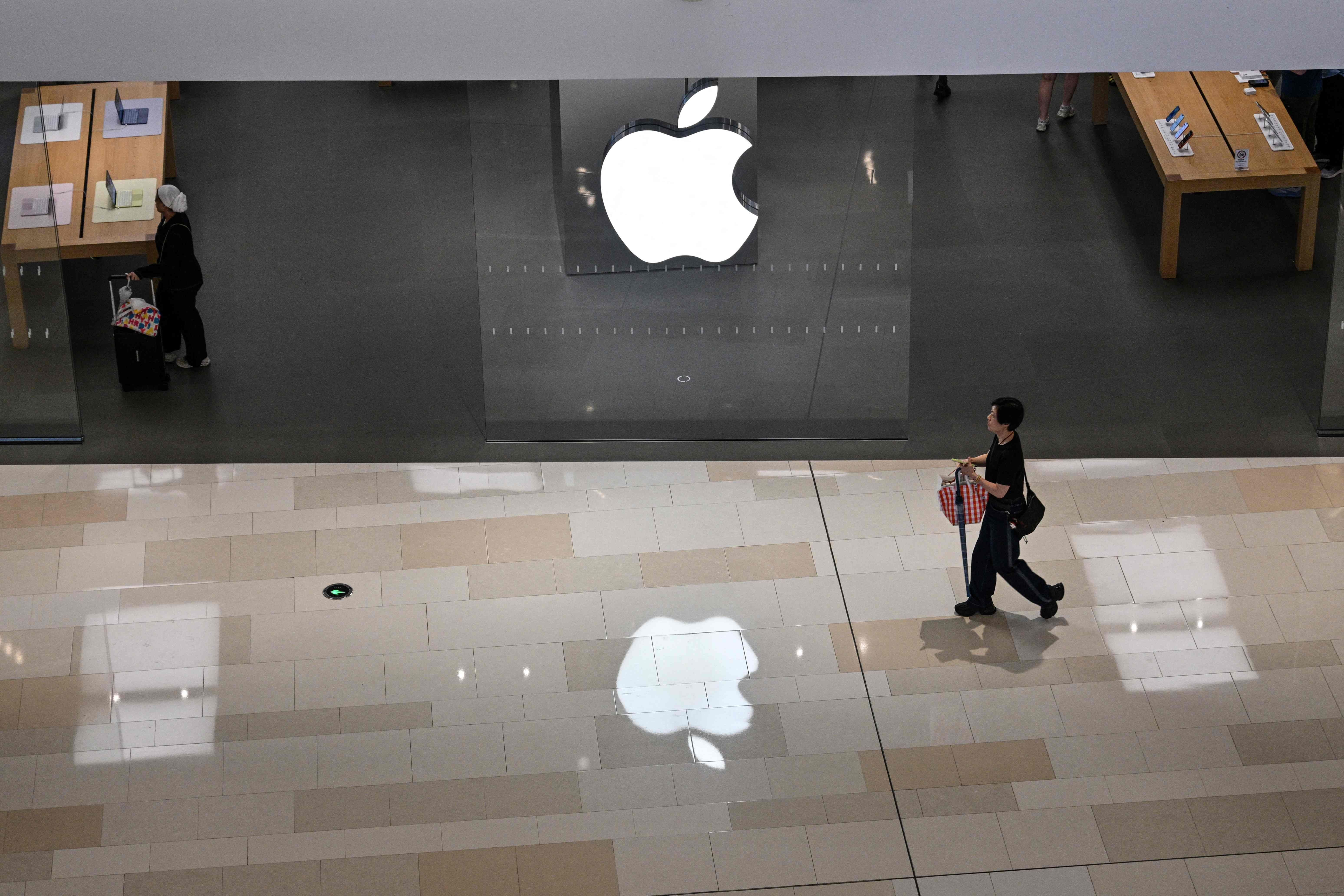Menschen gehen an einem Apple Store in einem Einkaufszentrum in Shanghai vorbei.