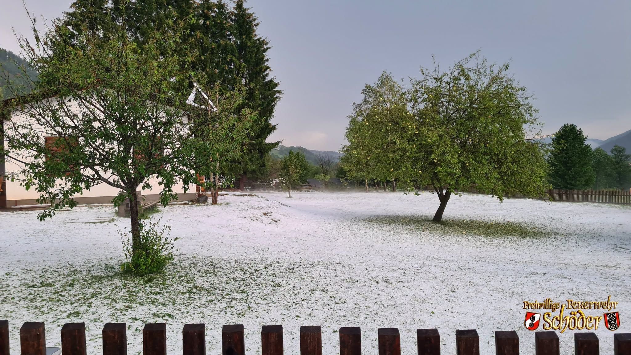 Ein Garten in der Steiermark ist nach einem Hagelsturm mit weißem Hagel bedeckt.