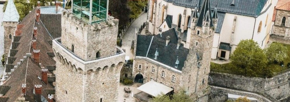 Luftaufnahme von Schloss Rothschild mit steinernen Türmen und historischen Gebäuden.