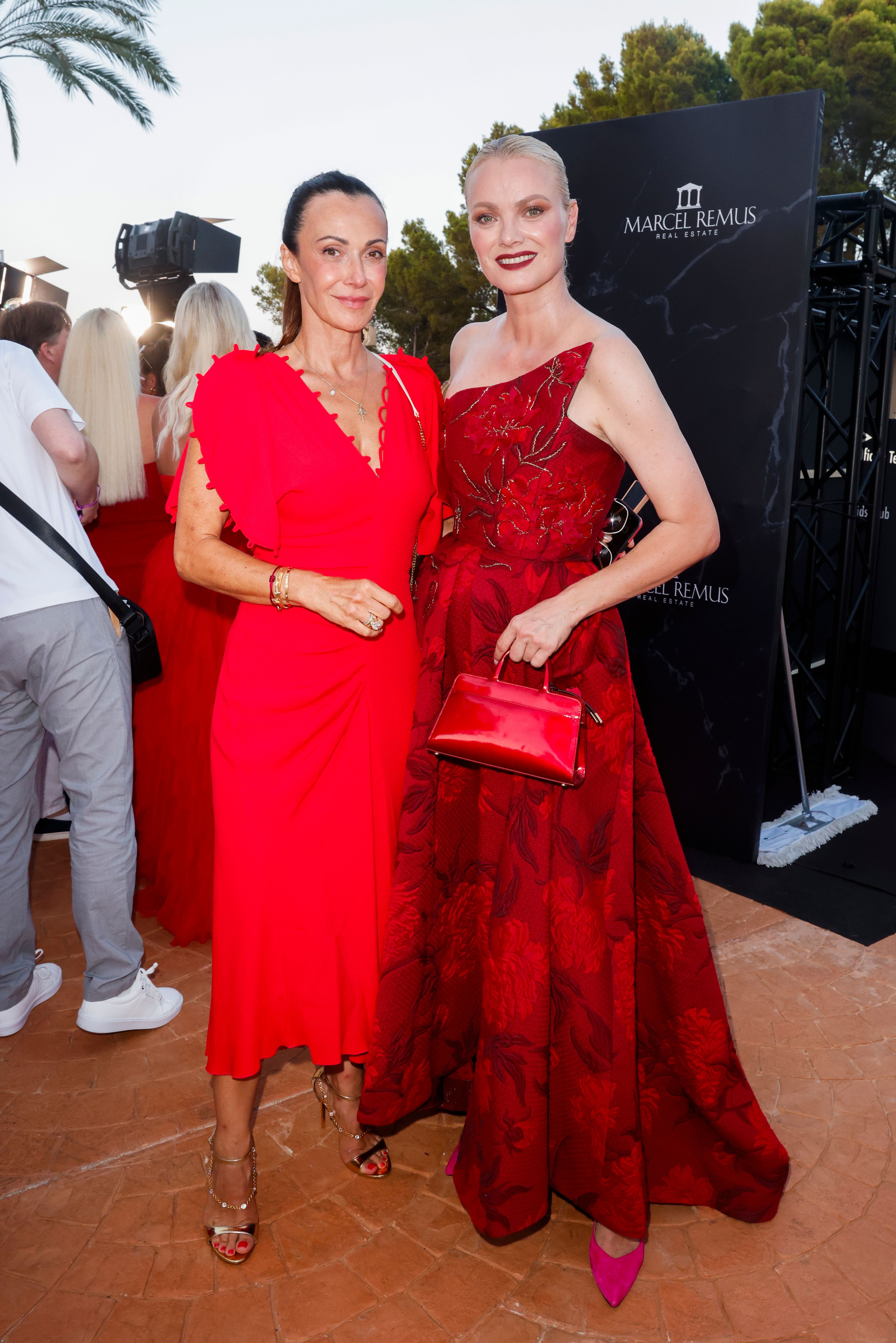 Zwei elegant gekleidete Frauen posieren auf einer Veranstaltung in Palma de Mallorca.