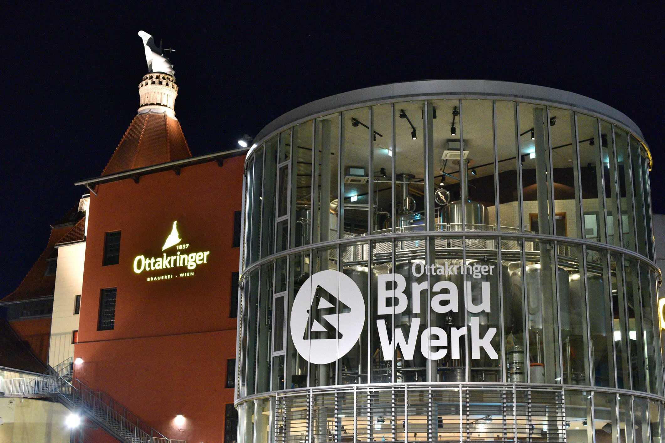 Nachtansicht der Ottakringer Brauerei in Wien mit beleuchtetem Schild und modernen Brauanlagen.