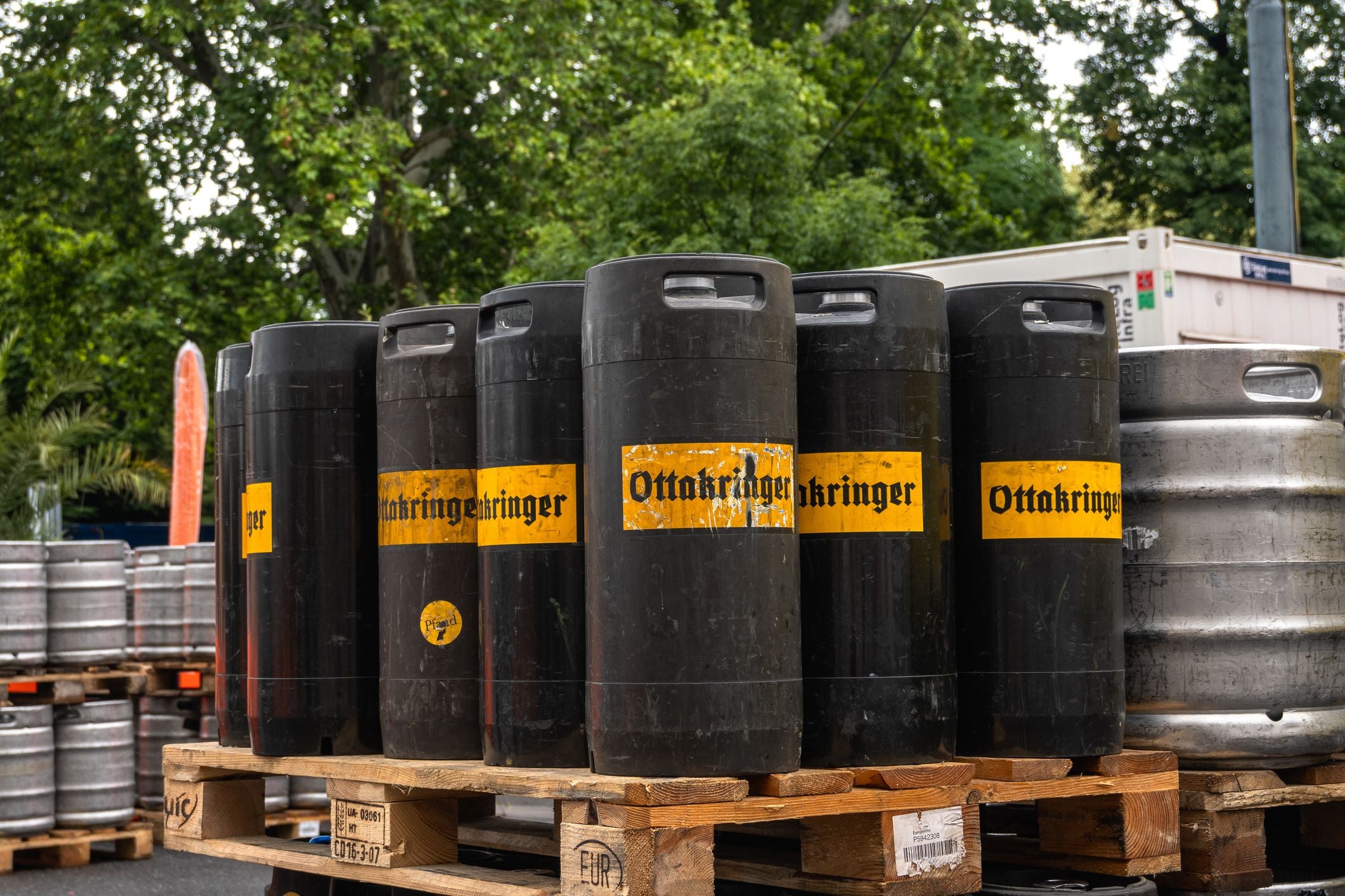Mehrere Ottakringer-Bierfässer stehen im Freien auf einer Holzpalette.