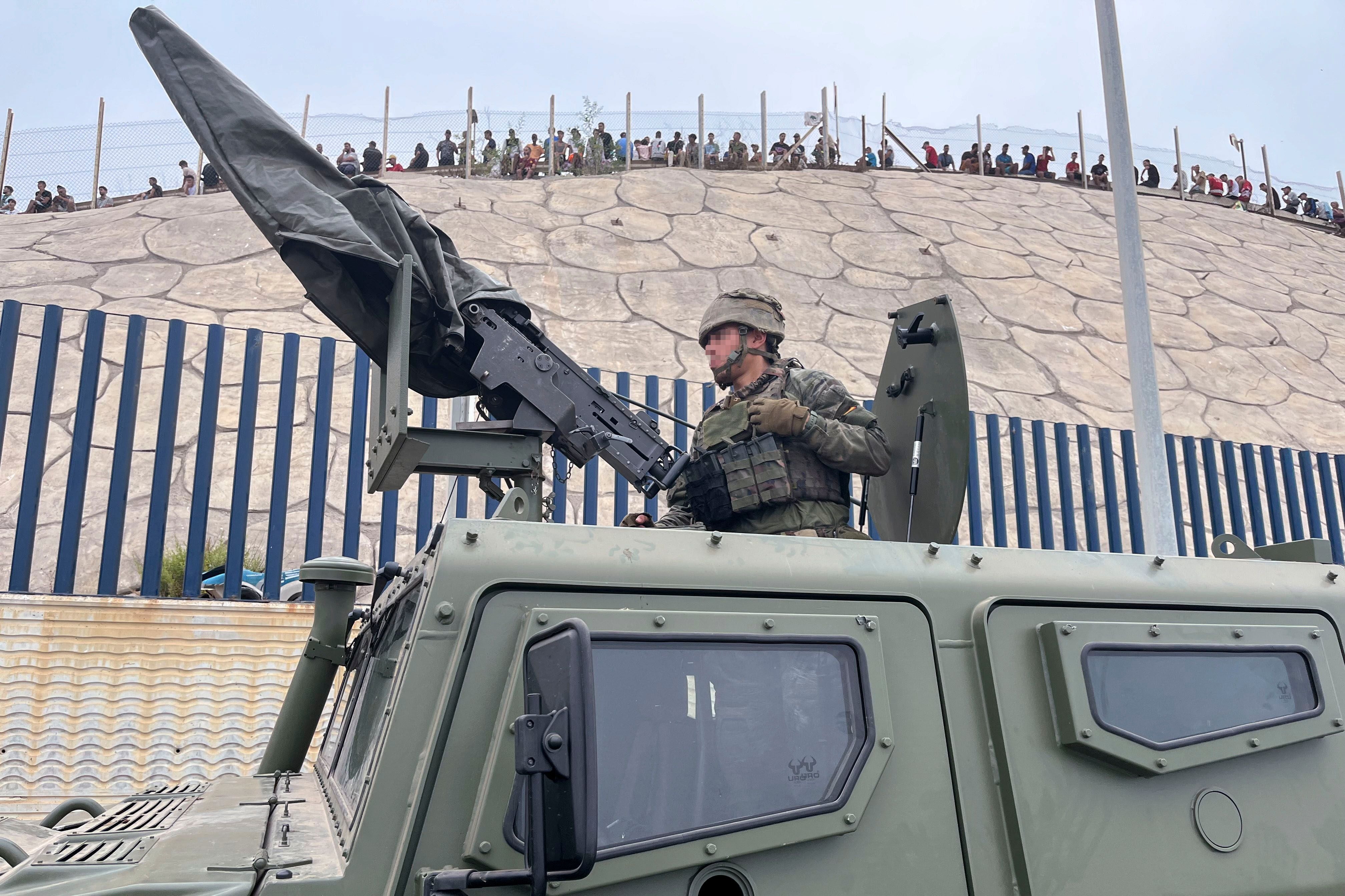 Ein spanischer Soldat steht bewaffnet auf einem Militärfahrzeug am Grenzübergang in Ceuta.