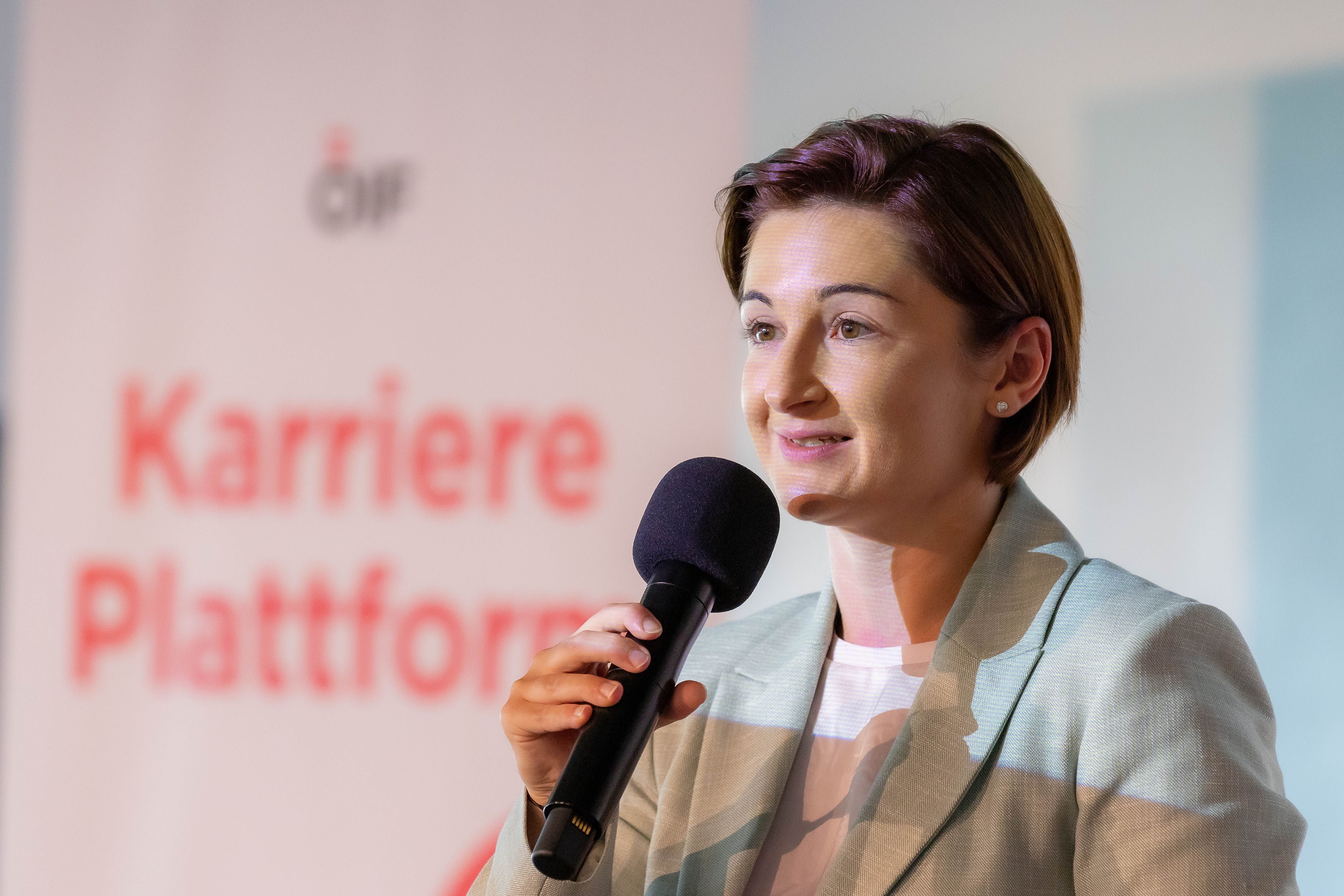 Frau spricht mit Mikrofon bei einer Veranstaltung der ÖIF-Karriereplattform in Salzburg.