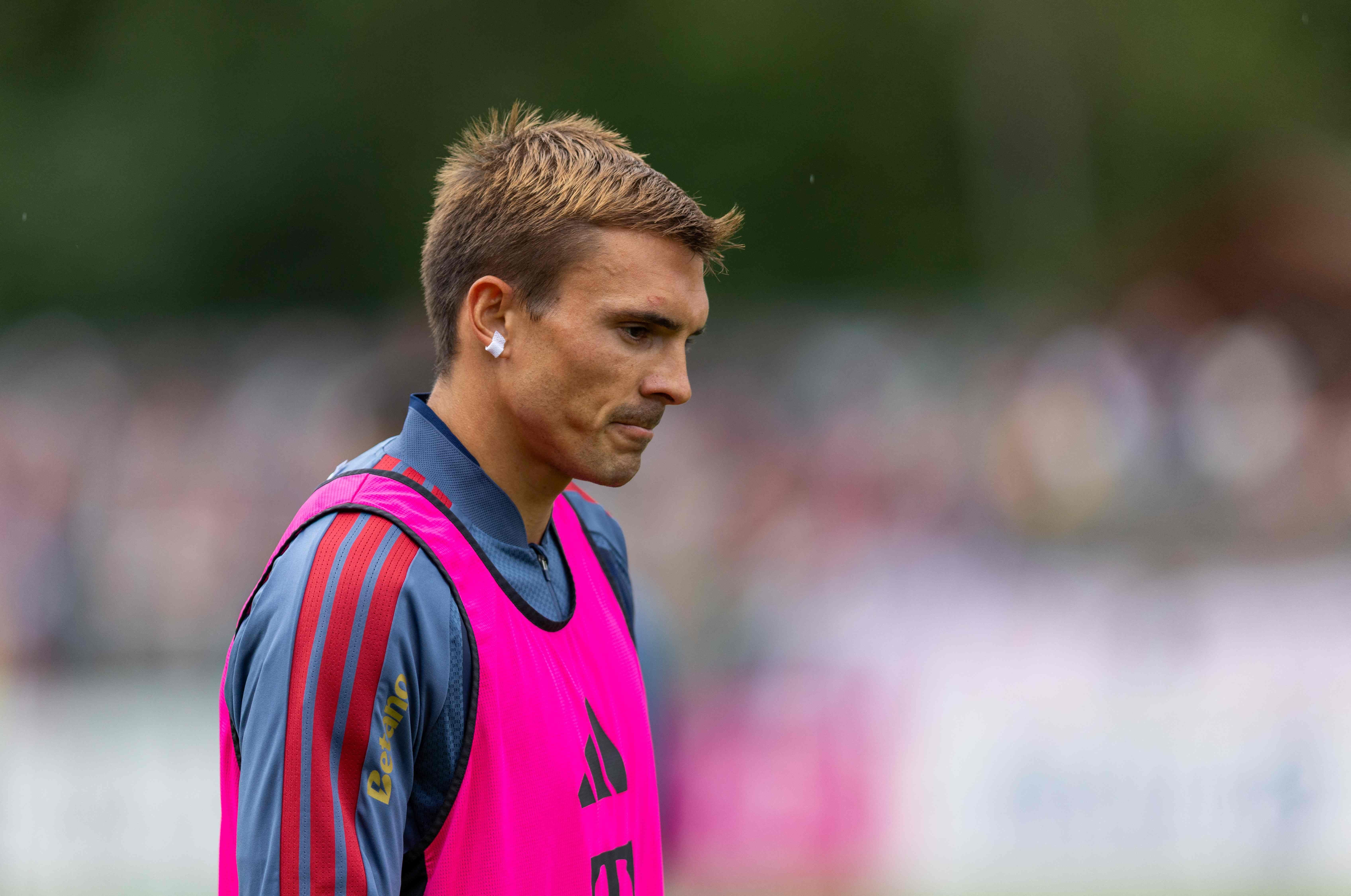 Ein Fußballspieler im pinken Trainingsleibchen bei einer Trainingseinheit im Freien.