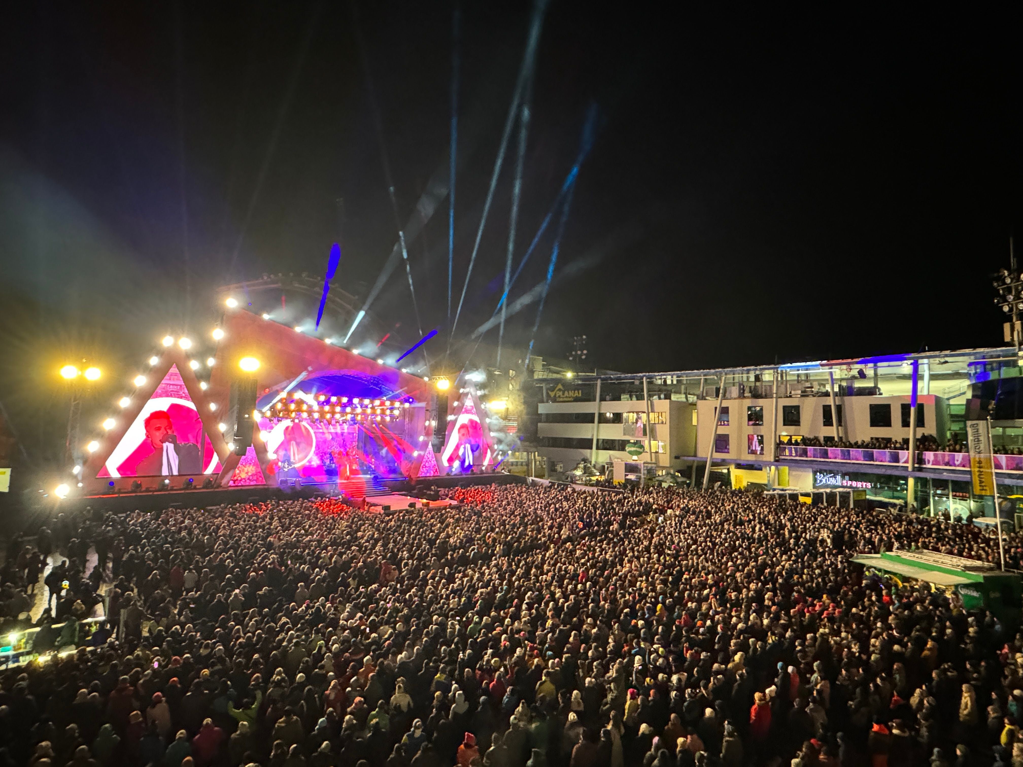 Großes Open-Air-Konzert in Schladming mit Menschenmenge vor beleuchteter Bühne bei Nacht.