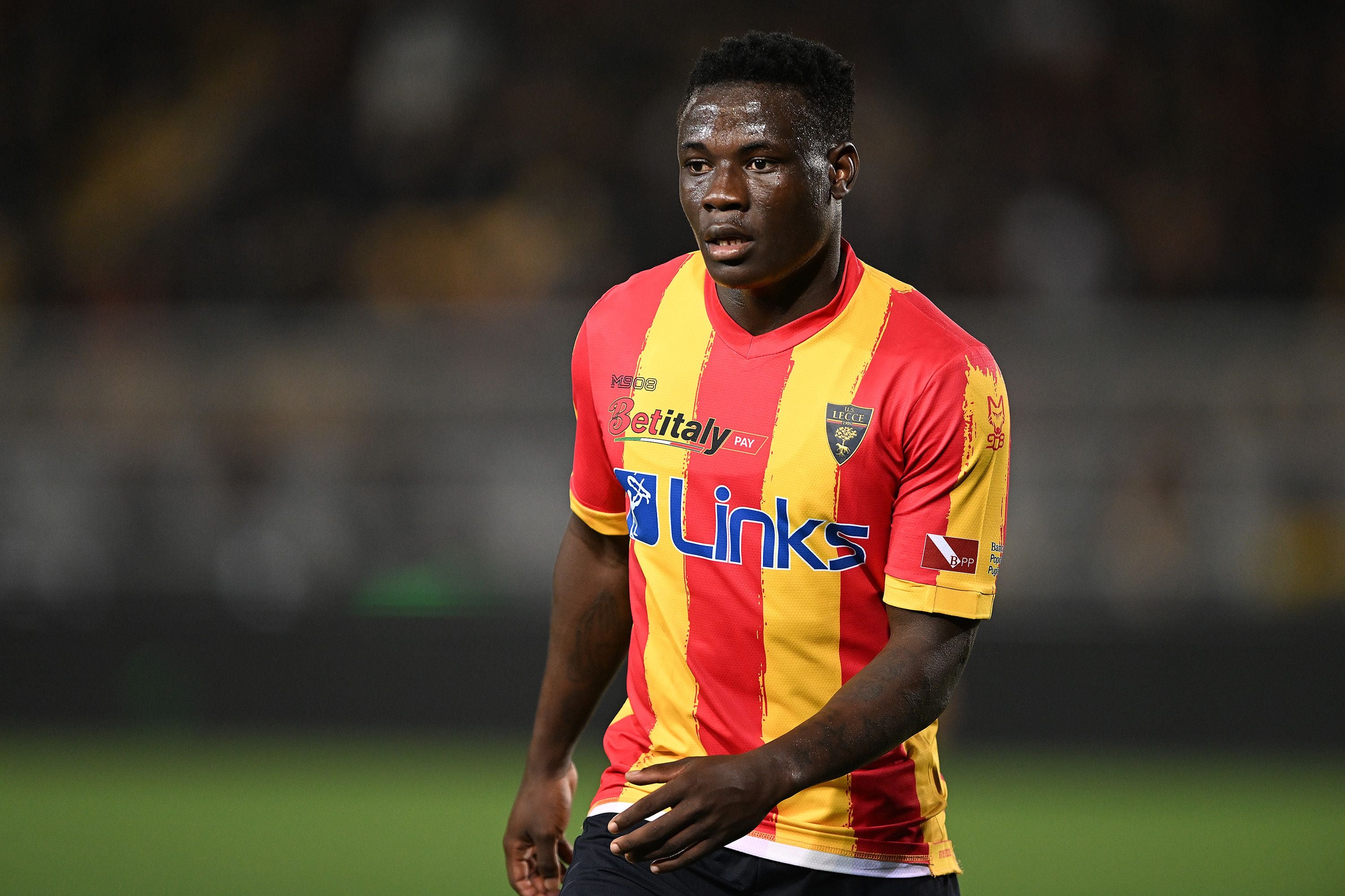 Ein Fußballspieler im rot-gelben US Lecce-Trikot läuft über das Spielfeld.
