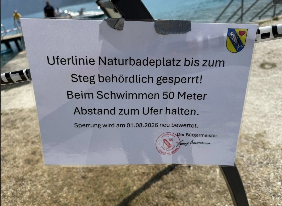 Hinweisschild am See: Uferlinie bis Steg gesperrt, 50 Meter Abstand beim Schwimmen halten.