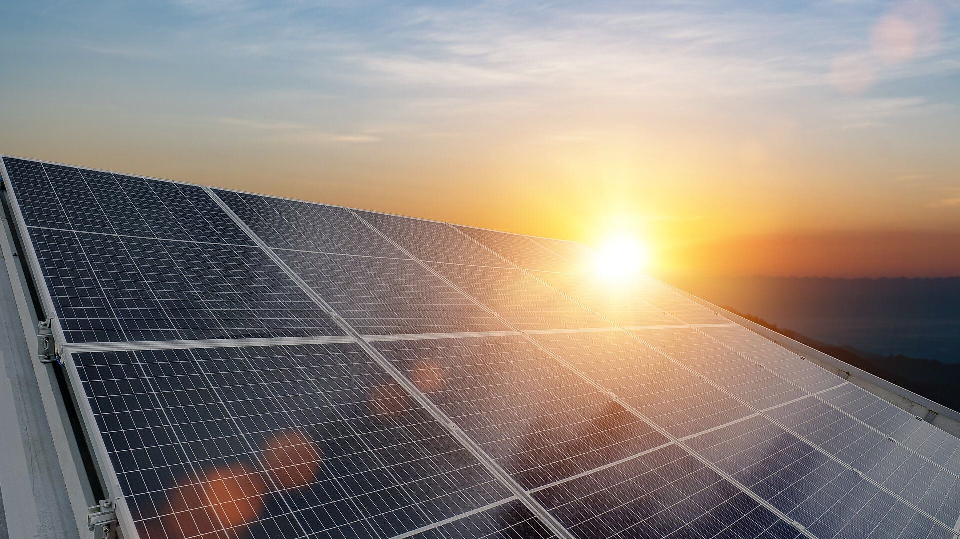Solaranlage mit Sonnenuntergang im Hintergrund, Symbol für erneuerbare Energien.