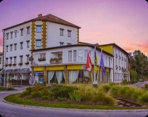 Touristen-Pension im Waldviertel an einem Kreisverkehr bei Sonnenuntergang.