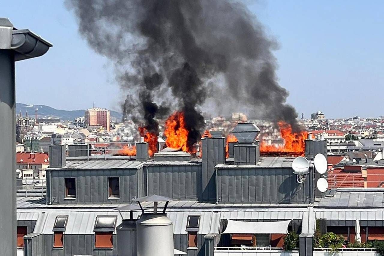 Große Flammen und schwarze Rauchwolken steigen von einem brennenden Dachstuhl in Meidling auf.