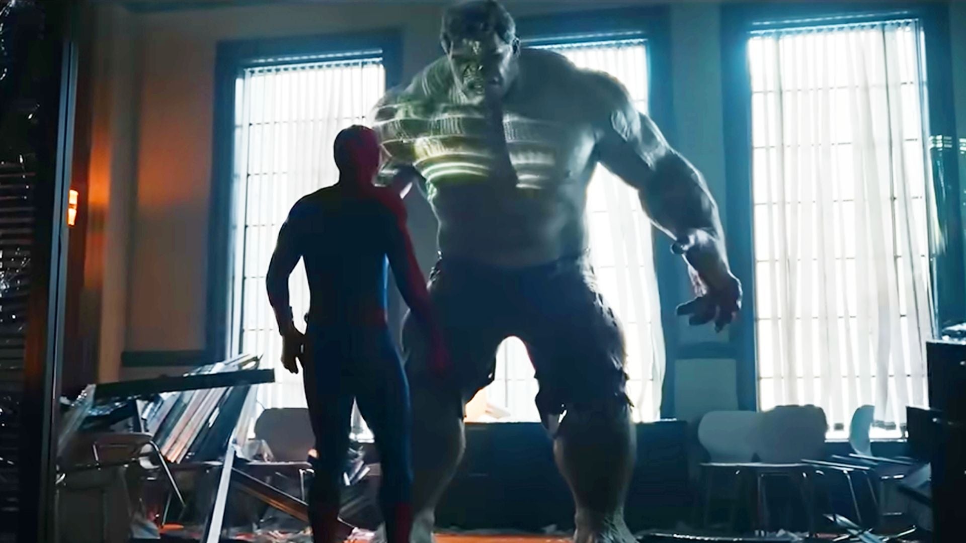 Spider-Man steht Hulk in einem zerstörten Raum gegenüber, Licht fällt durch die Fenster.