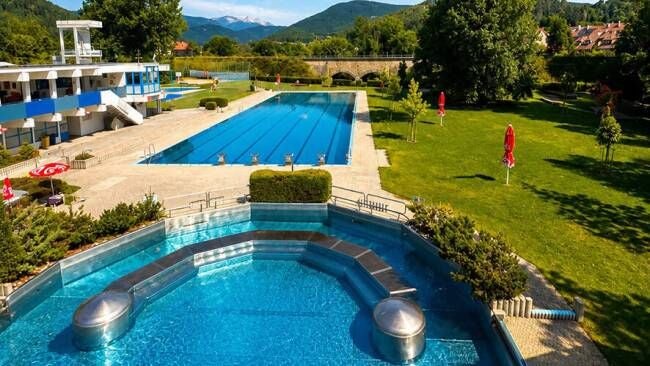 Modernes Freibad von Ternitz mit Schwimmbecken, Liegewiese und umliegender Natur im Sommer.