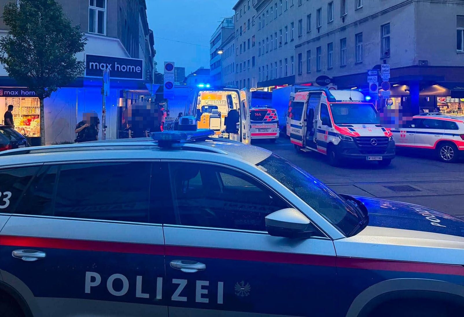 Mehrere Polizei- und Rettungsfahrzeuge mit Blaulicht bei einem nächtlichen Einsatz in einer Stadtstraße.