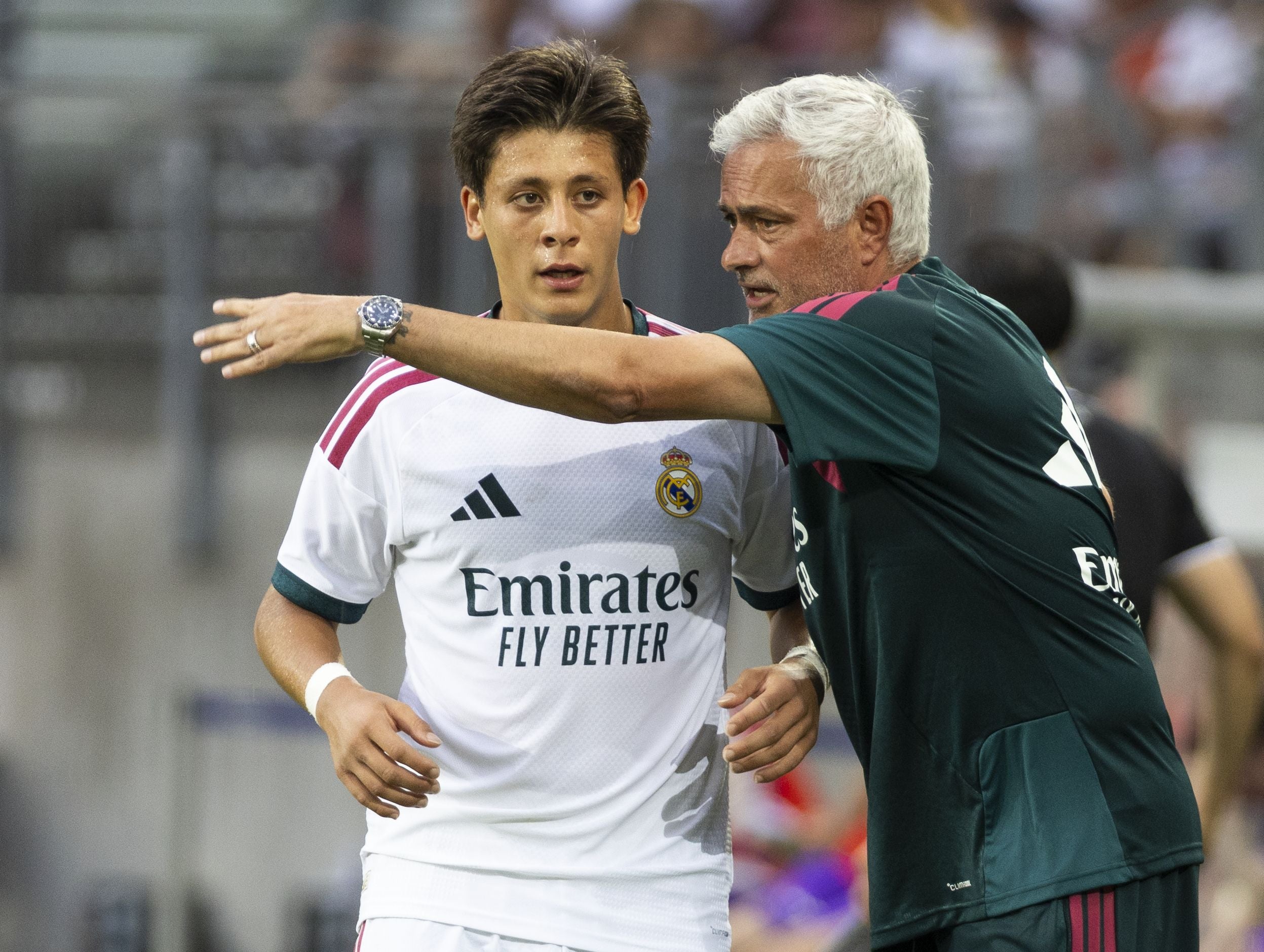 Ein Trainer gibt einem Real-Madrid-Spieler während eines Fußballspiels Anweisungen.