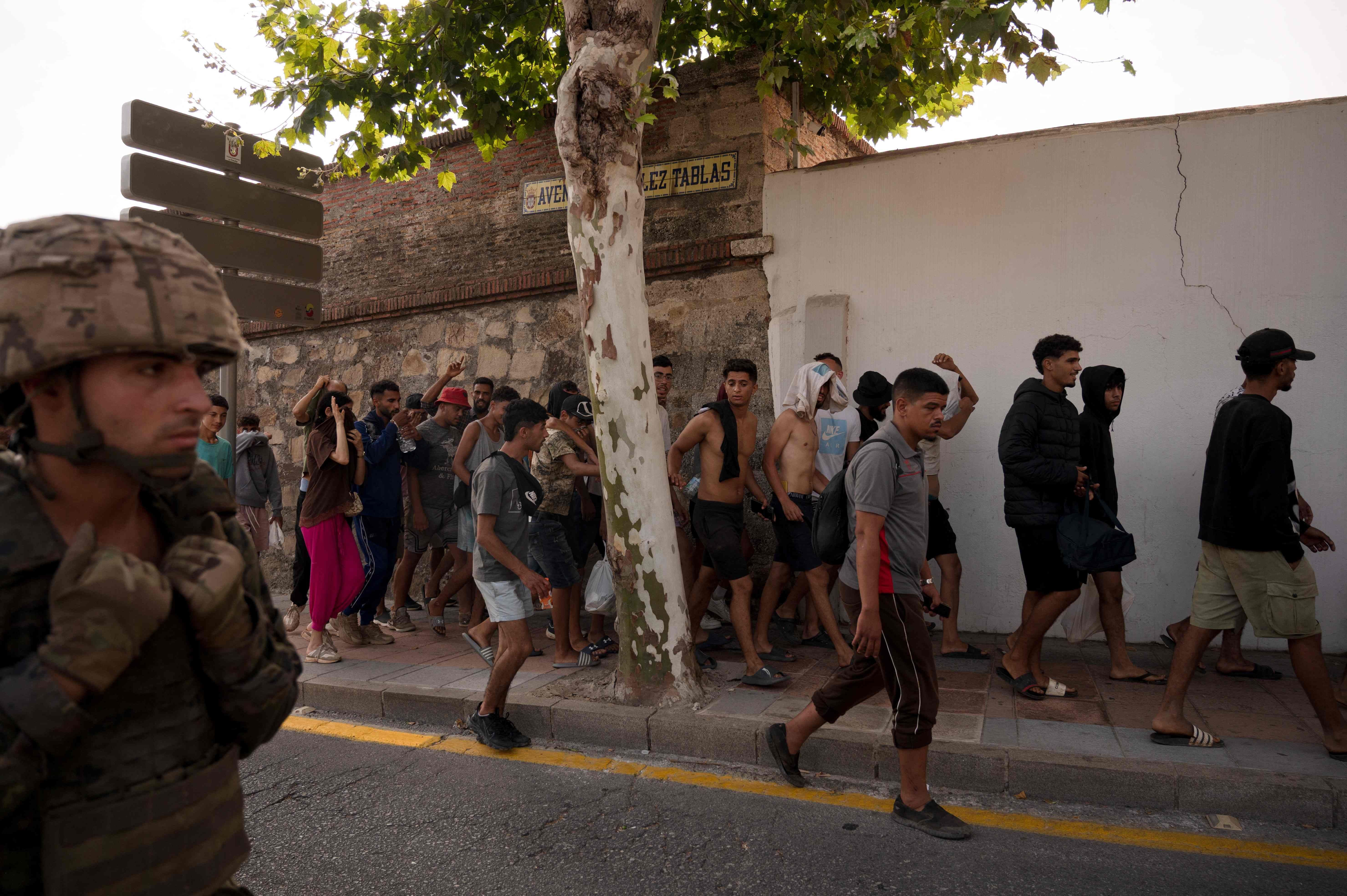 Ein spanischer Soldat eskortiert am 1. August eine Gruppe von Migranten auf ihrem Rückweg in Richtung der marokkanischen Grenze, nach deren illegalem Grenzübertritt in die spanische Exklave Ceuta.