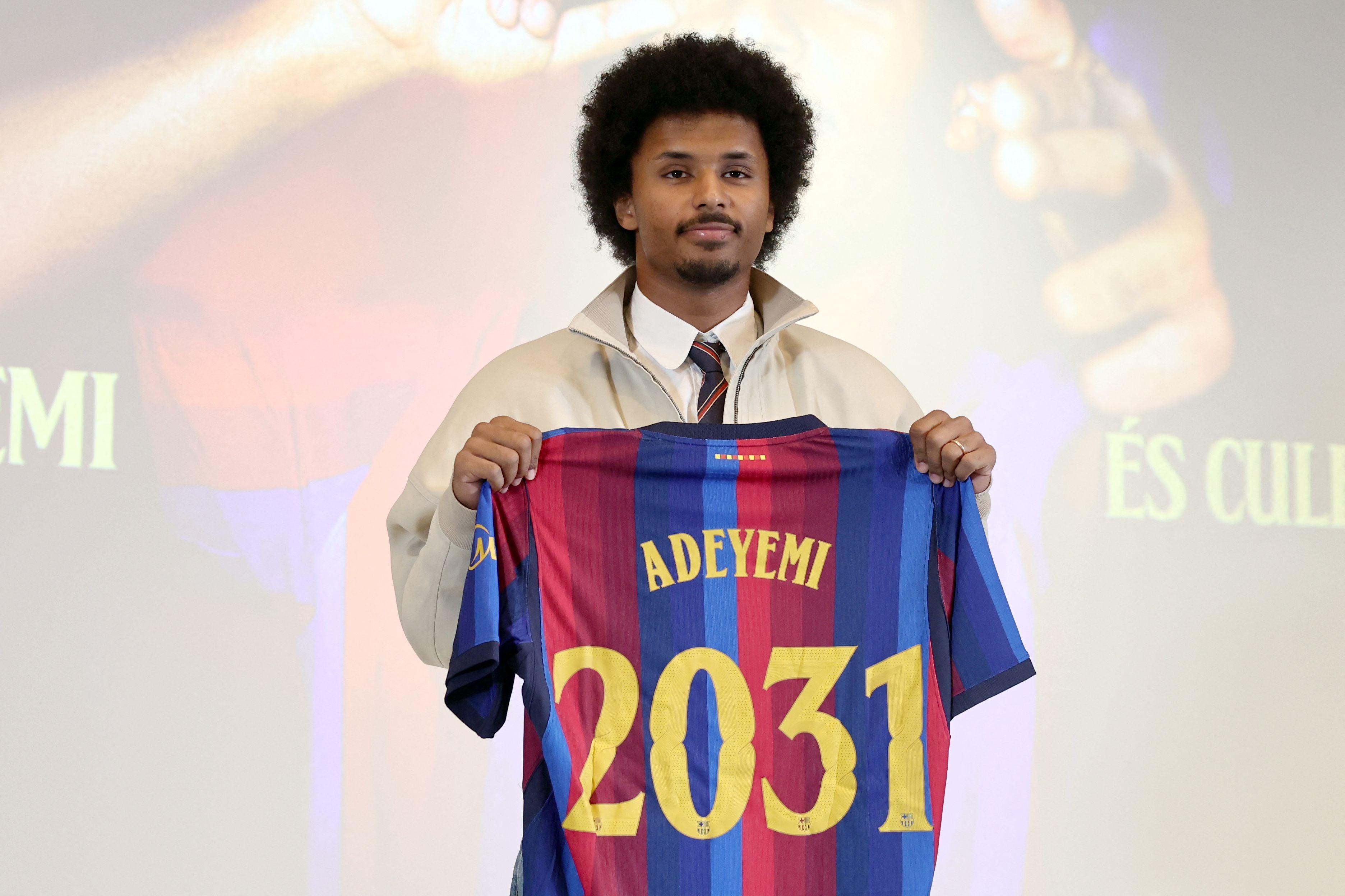Karim Adeyemi hält ein FC-Barcelona-Trikot mit seinem Namen und der Zahl 2031 hoch.