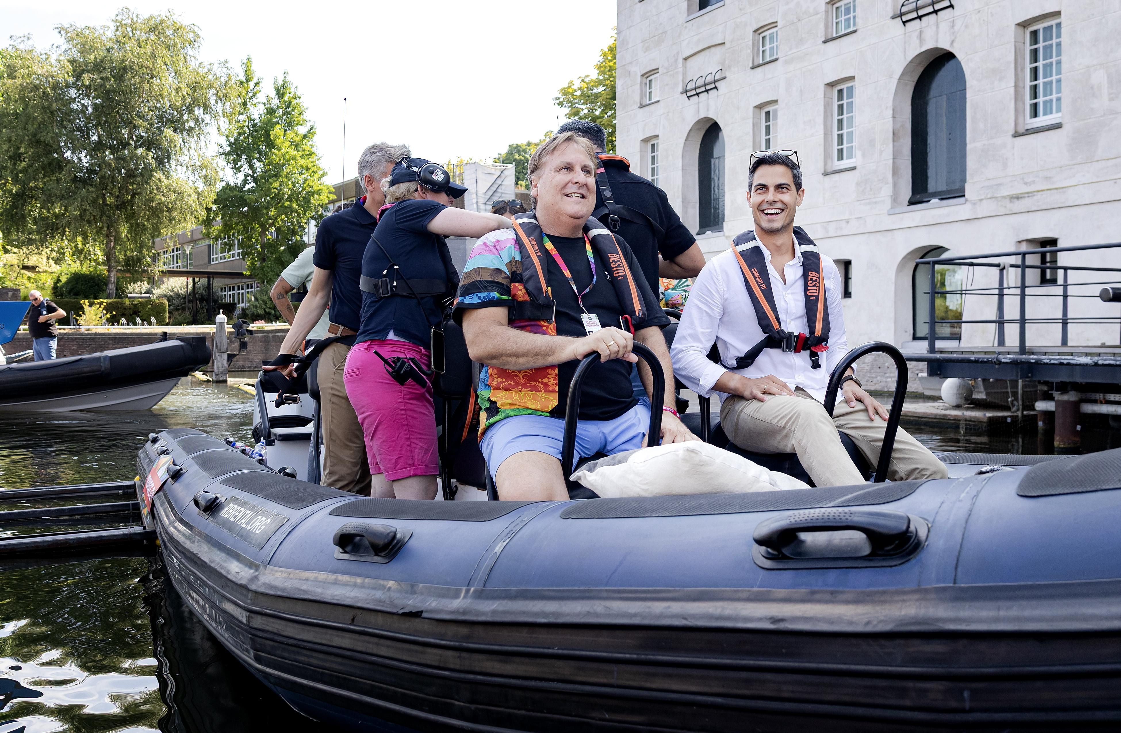Mehrere Menschen mit Schwimmwesten sitzen lachend in einem Schlauchboot auf einem Kanal.