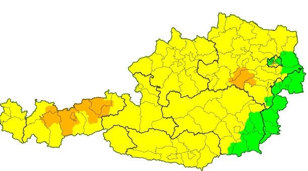 Wetterwarnkarte Österreichs mit gelben, orangen und grünen markierten Regionen.