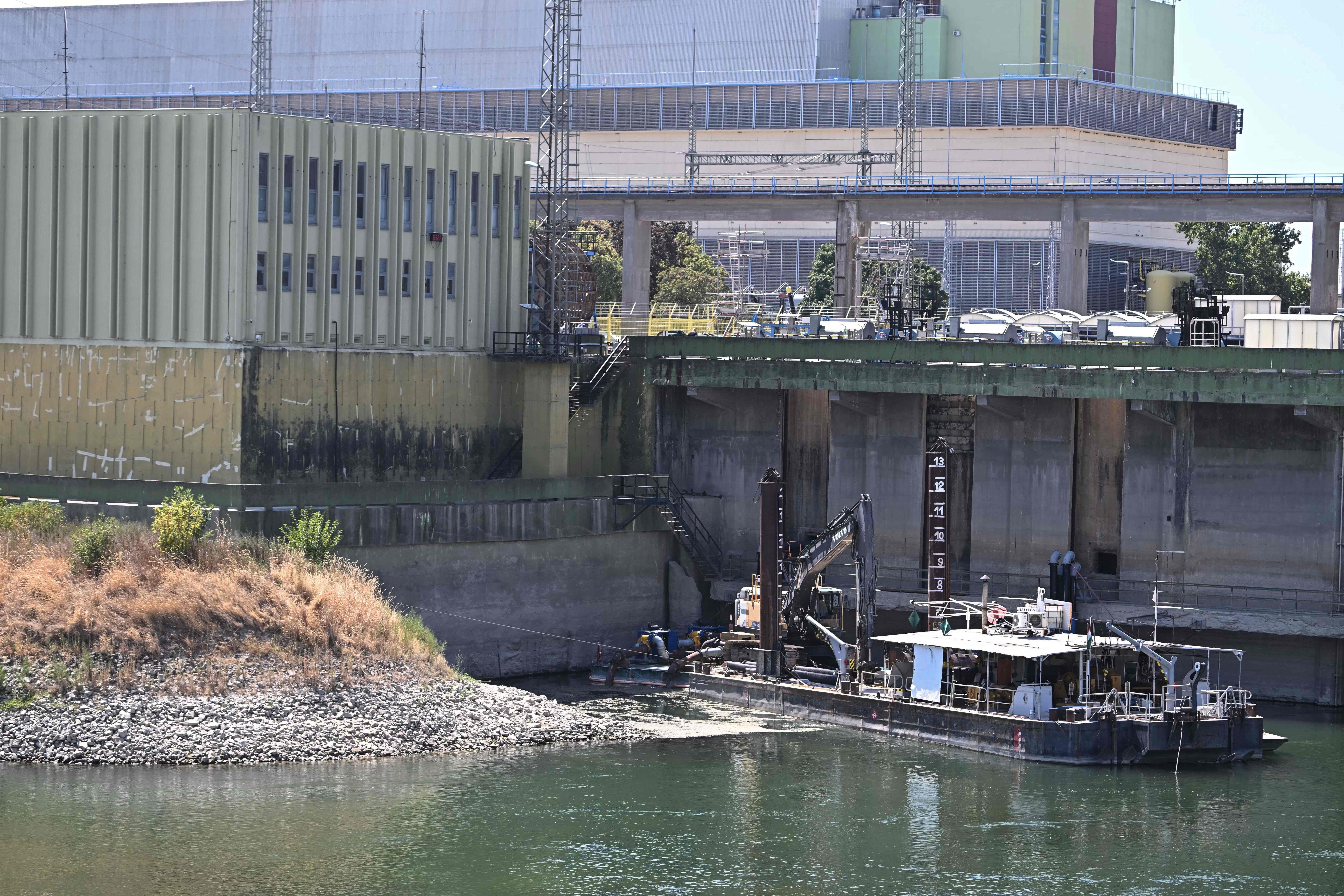 Ein Baggerboot arbeitet am Wasserkanal des Kernkraftwerks Paks bei niedrigen Wasserständen der Donau.