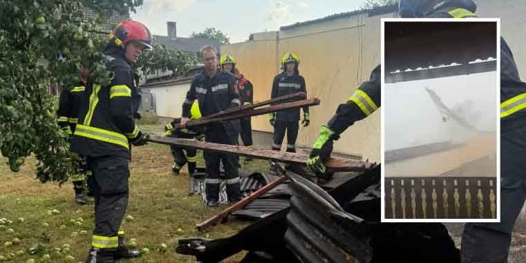 Feuerwehrleute räumen nach einem schweren Sturm Trümmer auf, Einsatzkräfte tragen Schutzkleidung.