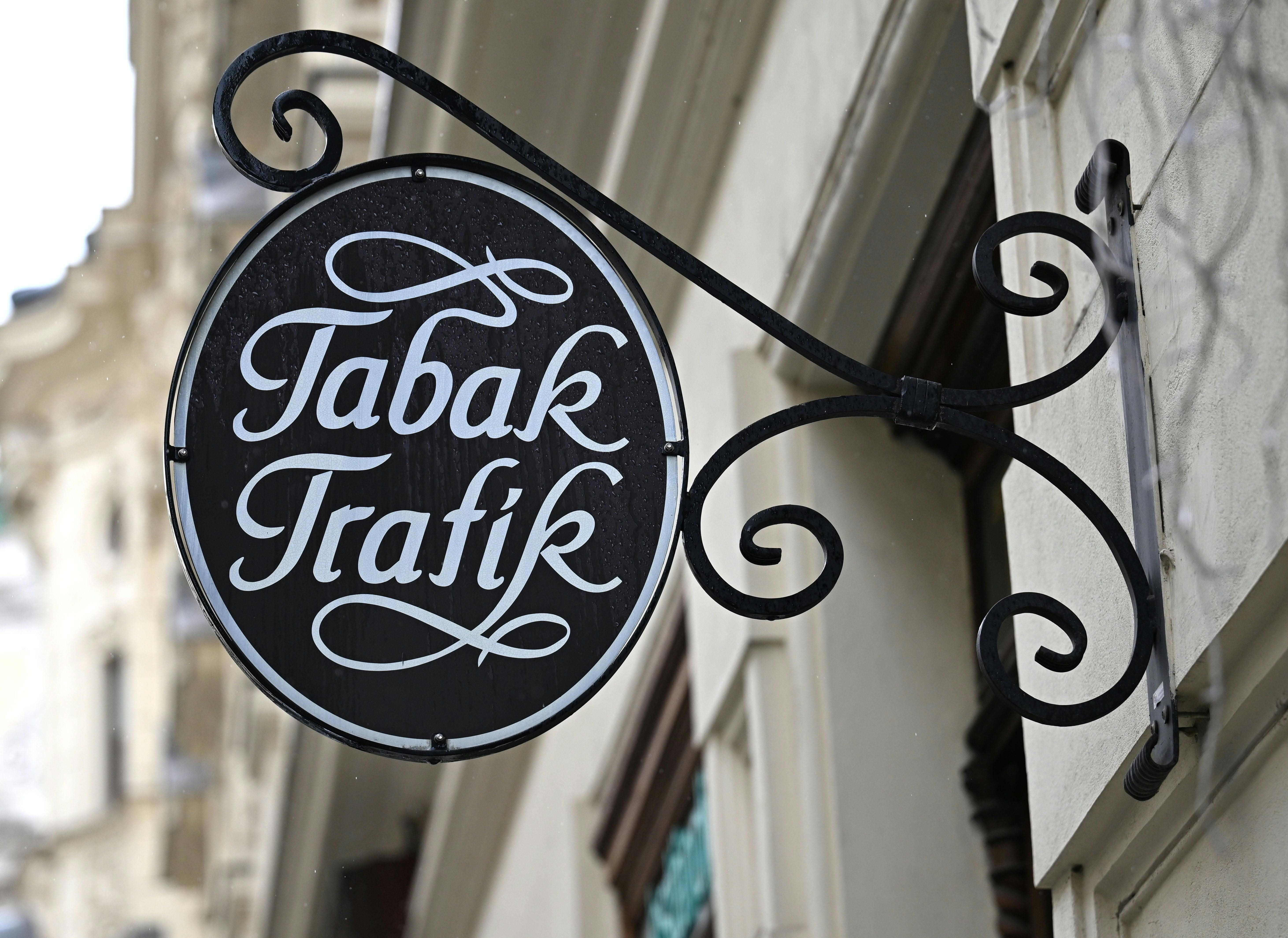 Ein rundes Schild mit der Aufschrift "Tabak Trafik" hängt an einer Hauswand in Wien.