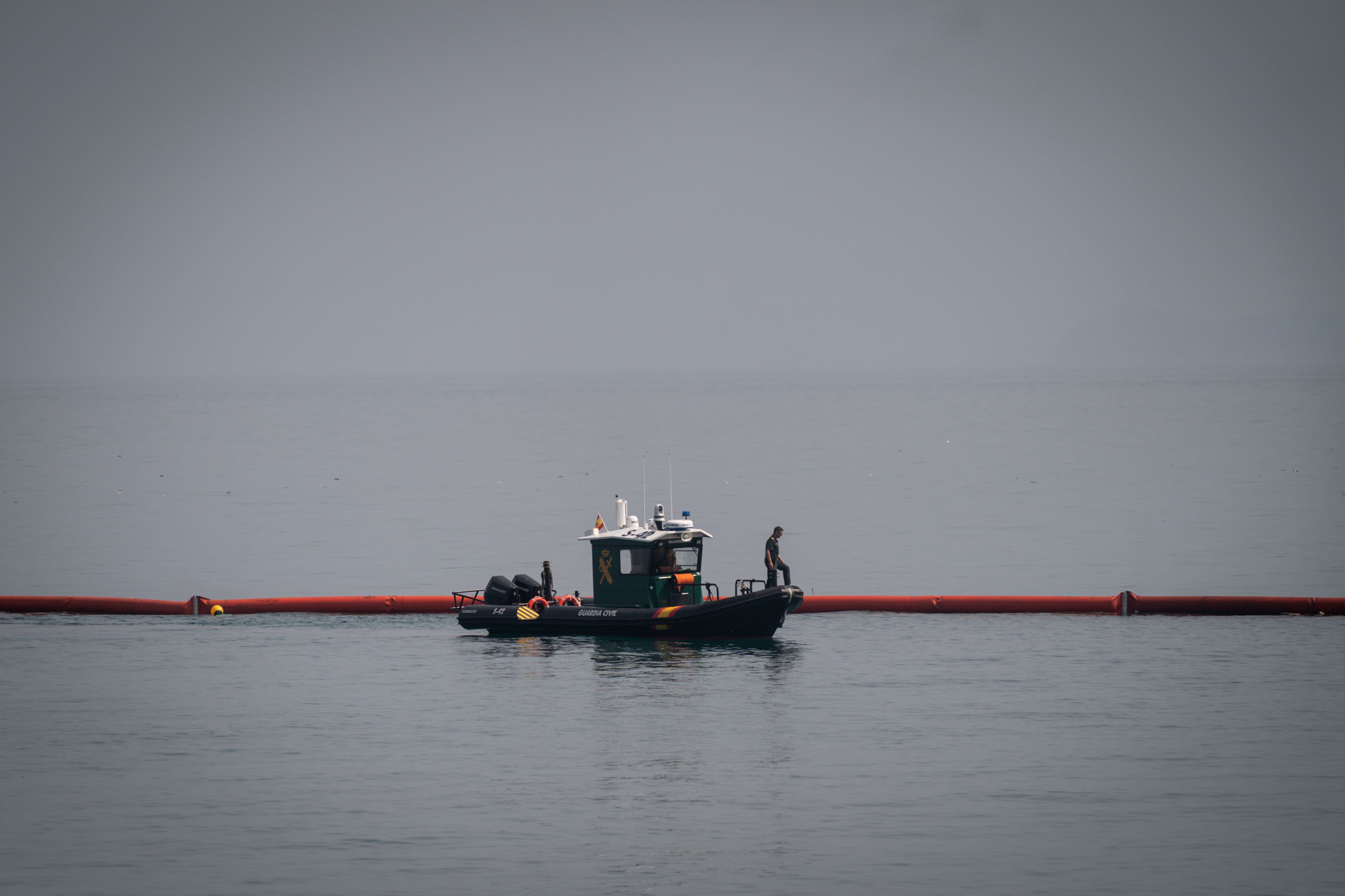 Ein Boot der Guardia Civil legt eine neue schwimmende Grenze im ruhigen Meer bei Ceuta an.