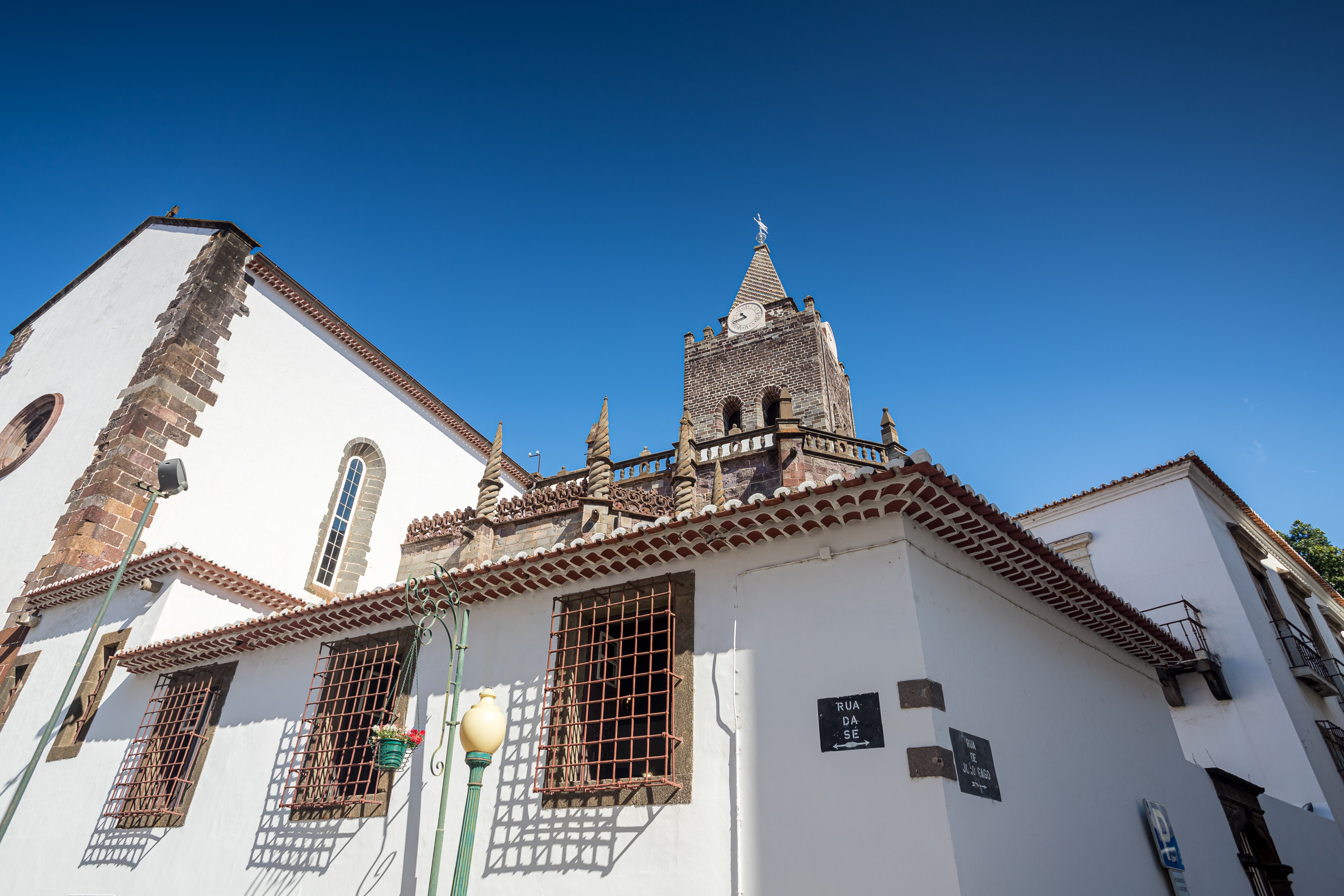 Kathedrale von Funchal mit Uhrenturm vor blauem Himmel in Madeira, Portugal.