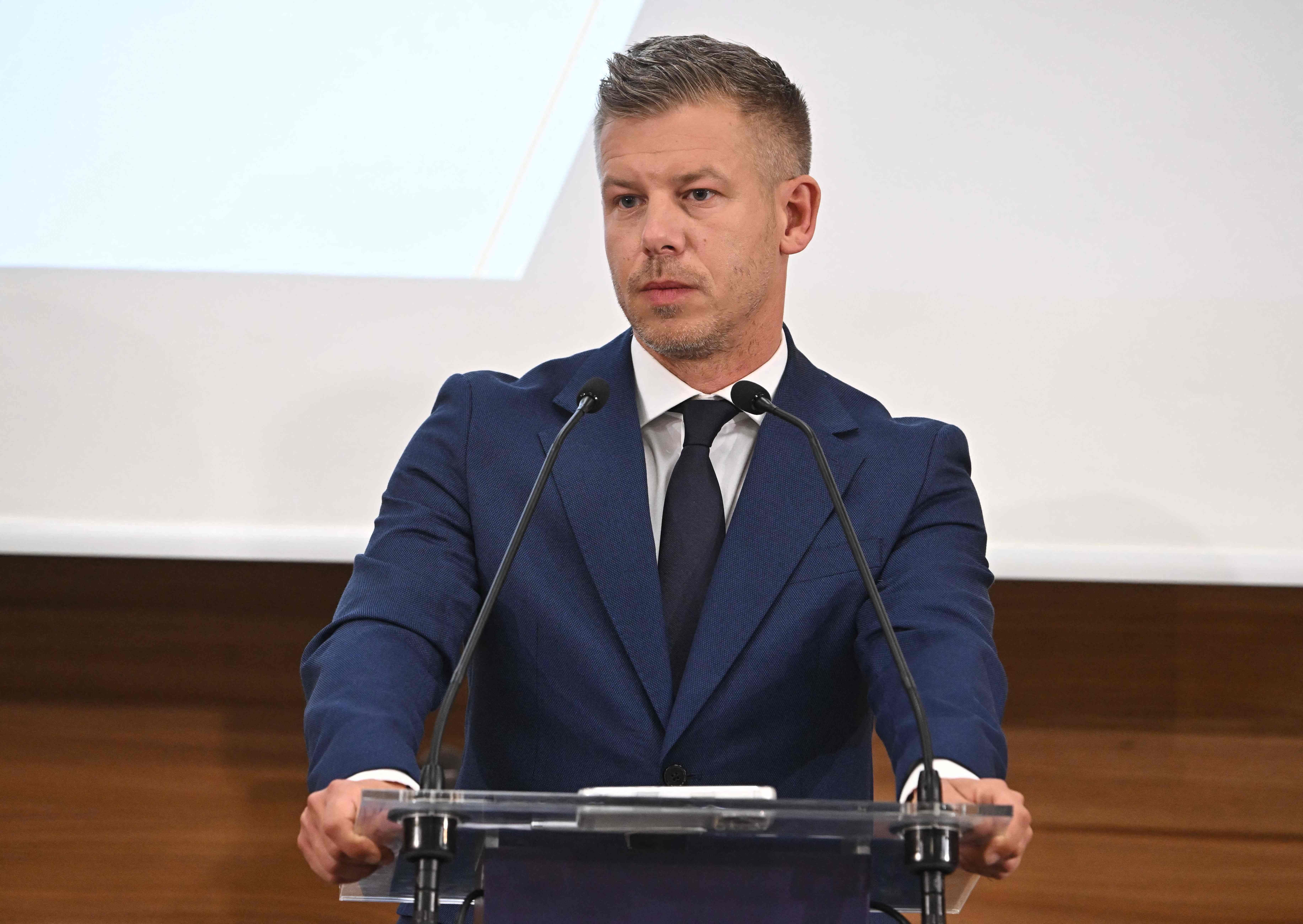 Ein Mann im Anzug spricht auf einer Pressekonferenz am Rednerpult mit zwei Mikrofonen.