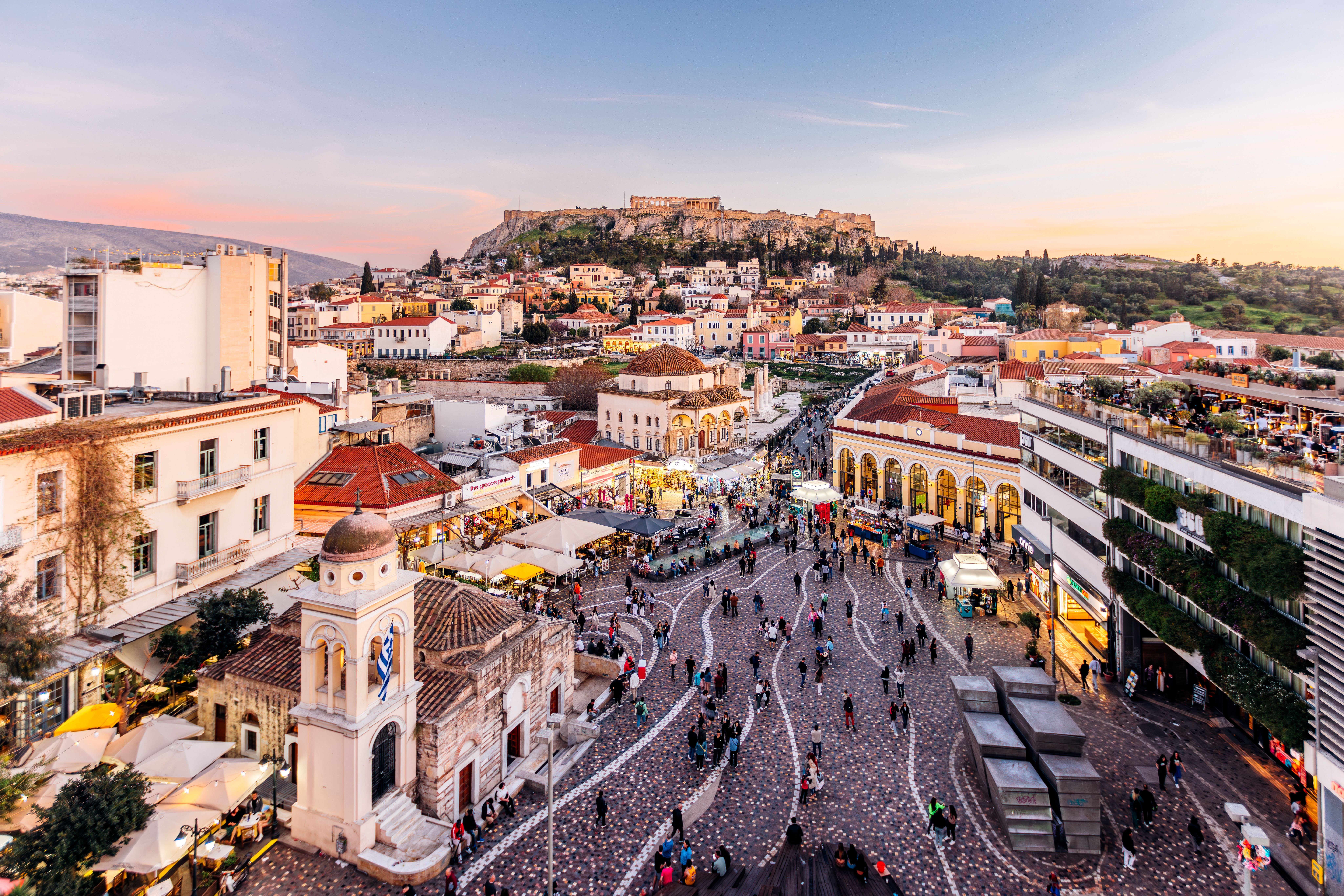 Blick auf den belebten Monastiraki-Platz in Athen mit der Akropolis im Hintergrund.