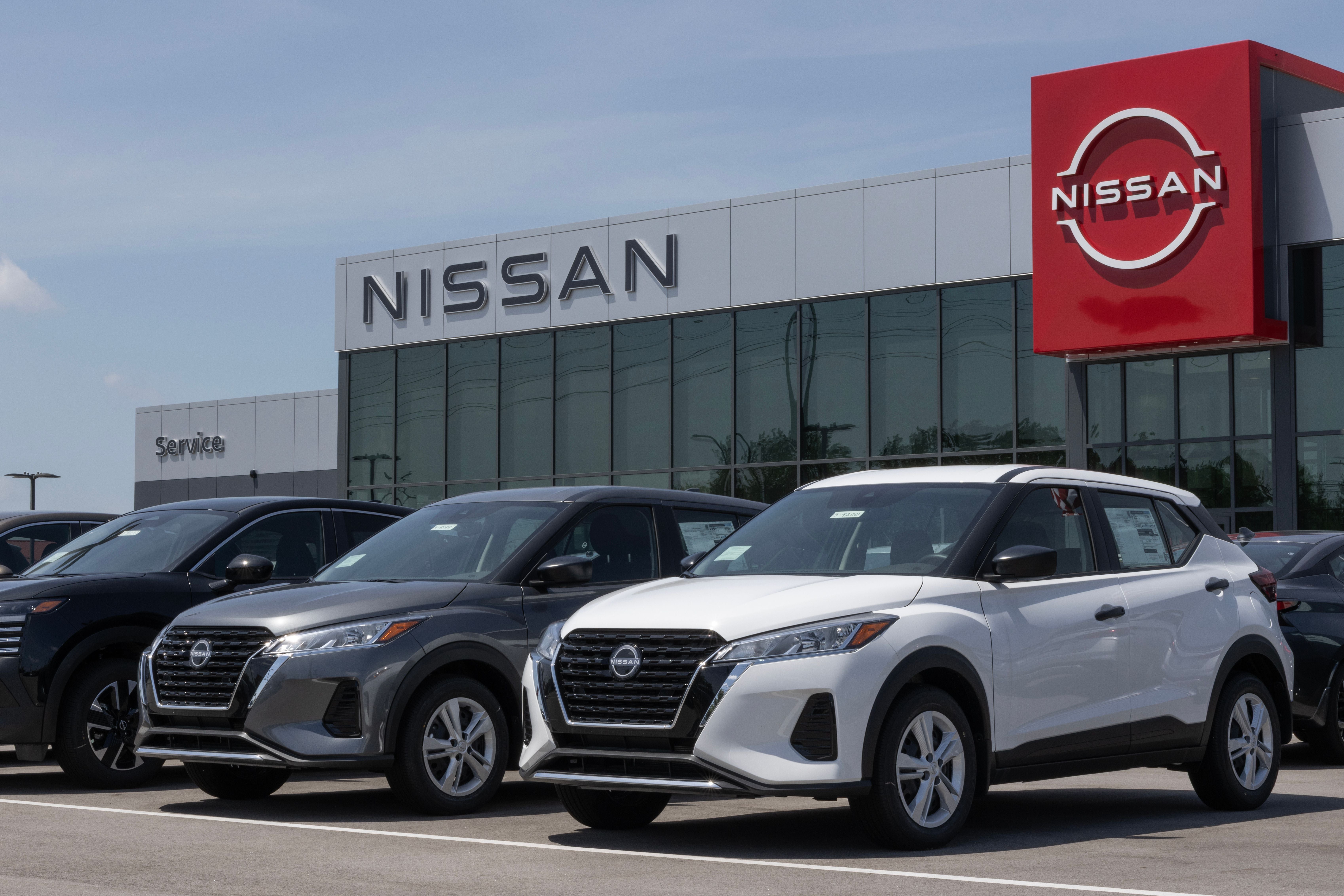 Mehrere Nissan Kicks SUVs stehen vor einem Nissan Autohaus zur Ausstellung bereit.