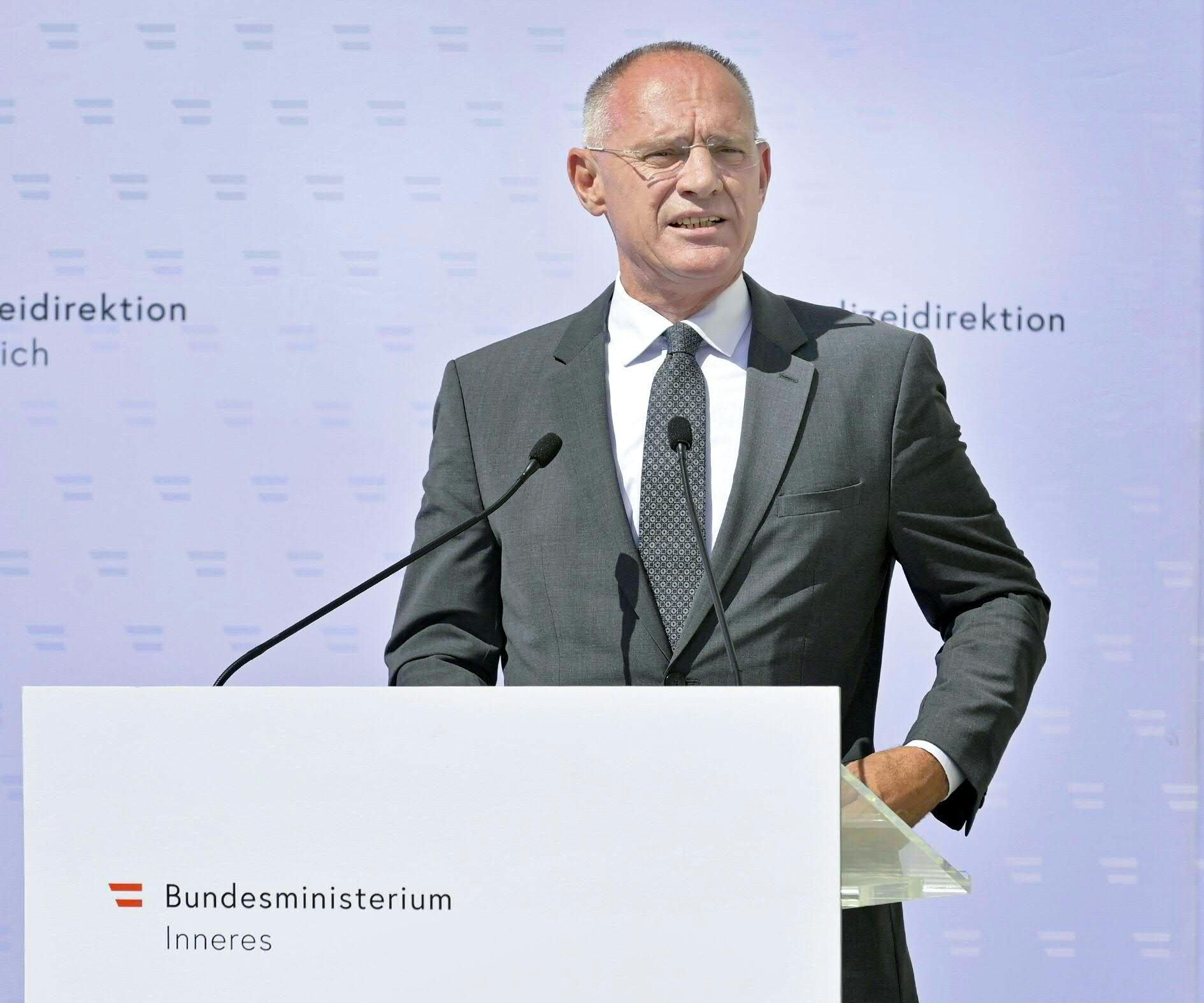 Ein Mann im Anzug spricht am Rednerpult des Bundesministeriums für Inneres bei einer Veranstaltung.
