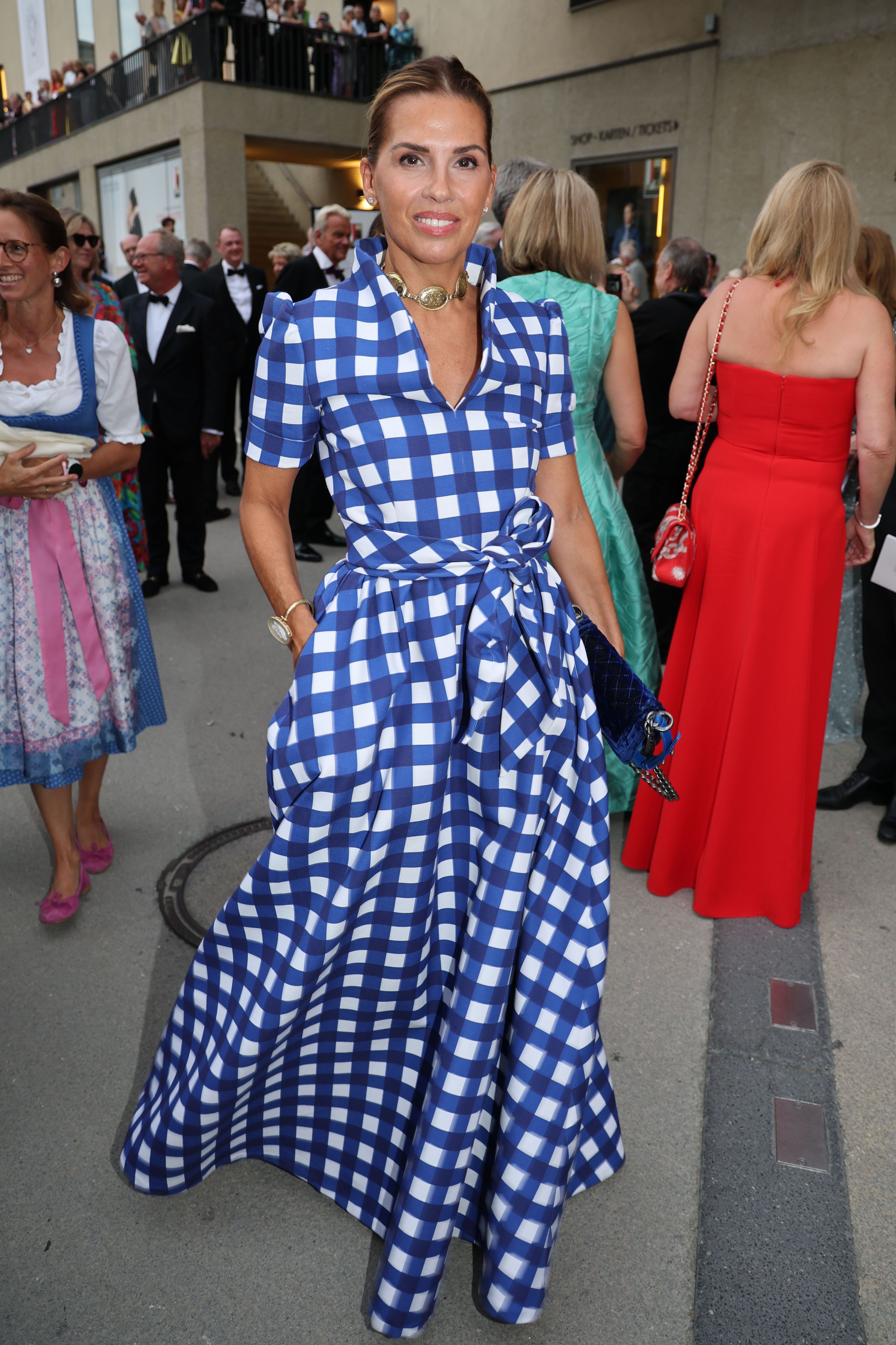 Frau in blau-weiß kariertem Abendkleid bei einer Veranstaltung der Salzburger Festspiele.