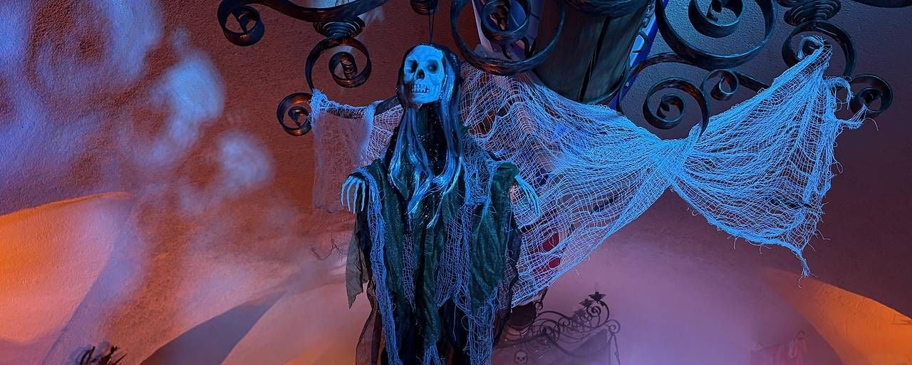 Eine skelettartige Halloween-Dekoration hängt in blauer Beleuchtung von der Decke.