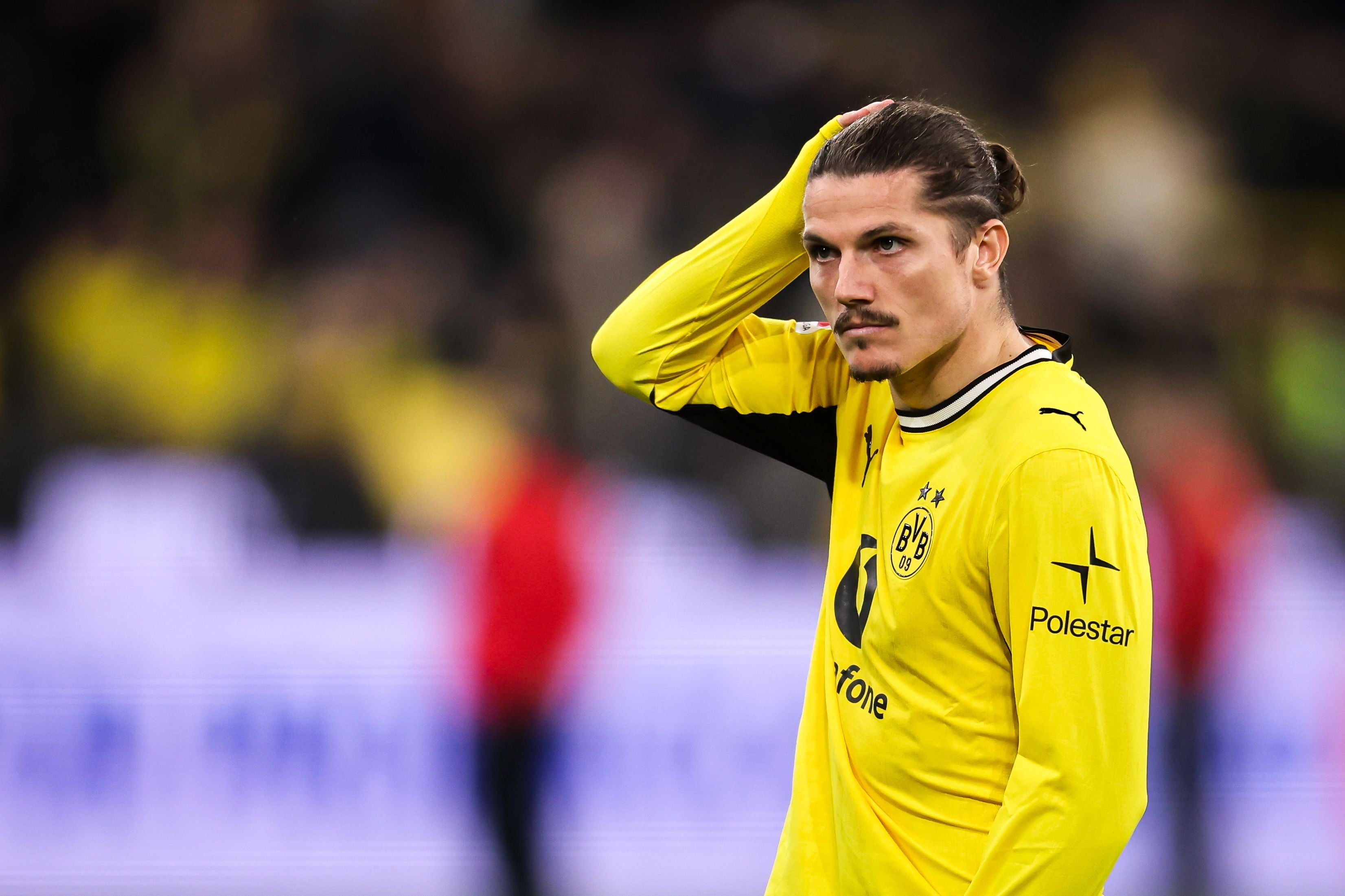Ein Fußballspieler von Borussia Dortmund fasst sich während eines Spiels nachdenklich an den Kopf.