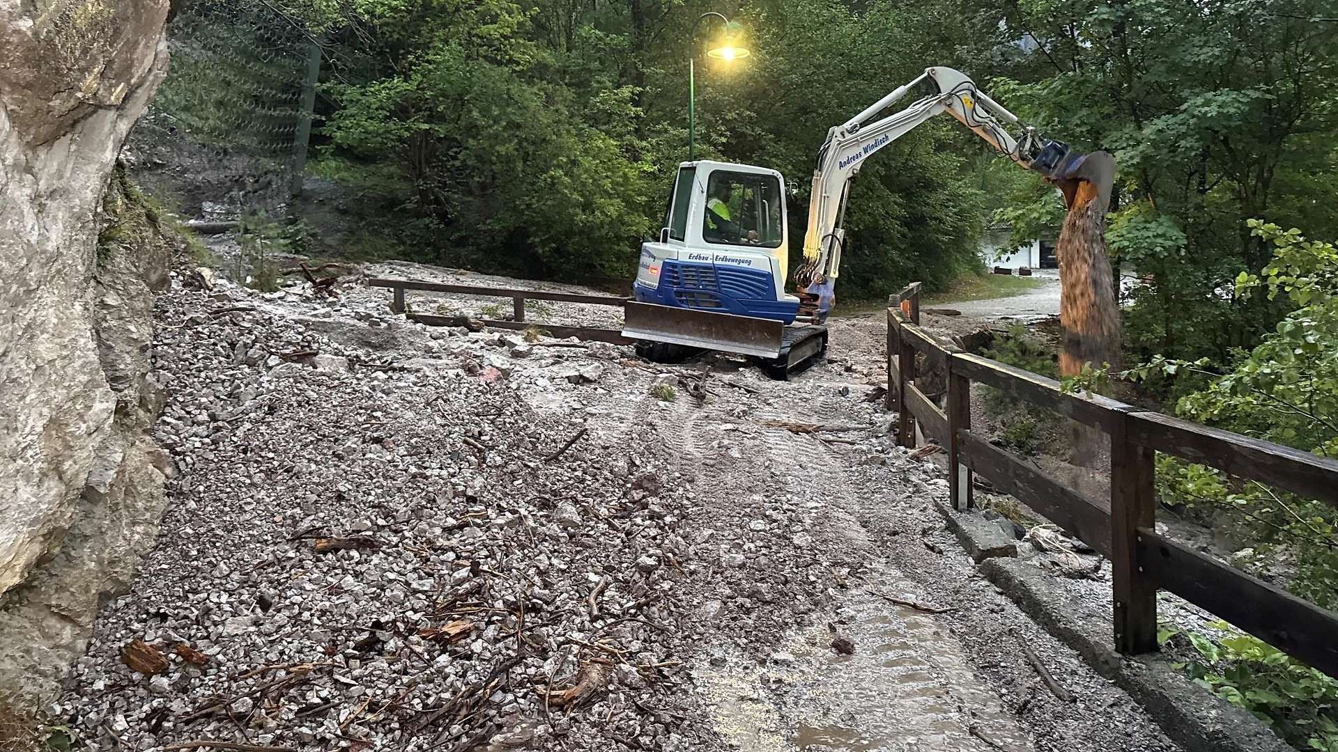 Ein Bagger räumt Geröll auf einem verschmutzten Weg in der Kundler Klamm nach einem Unwetter.