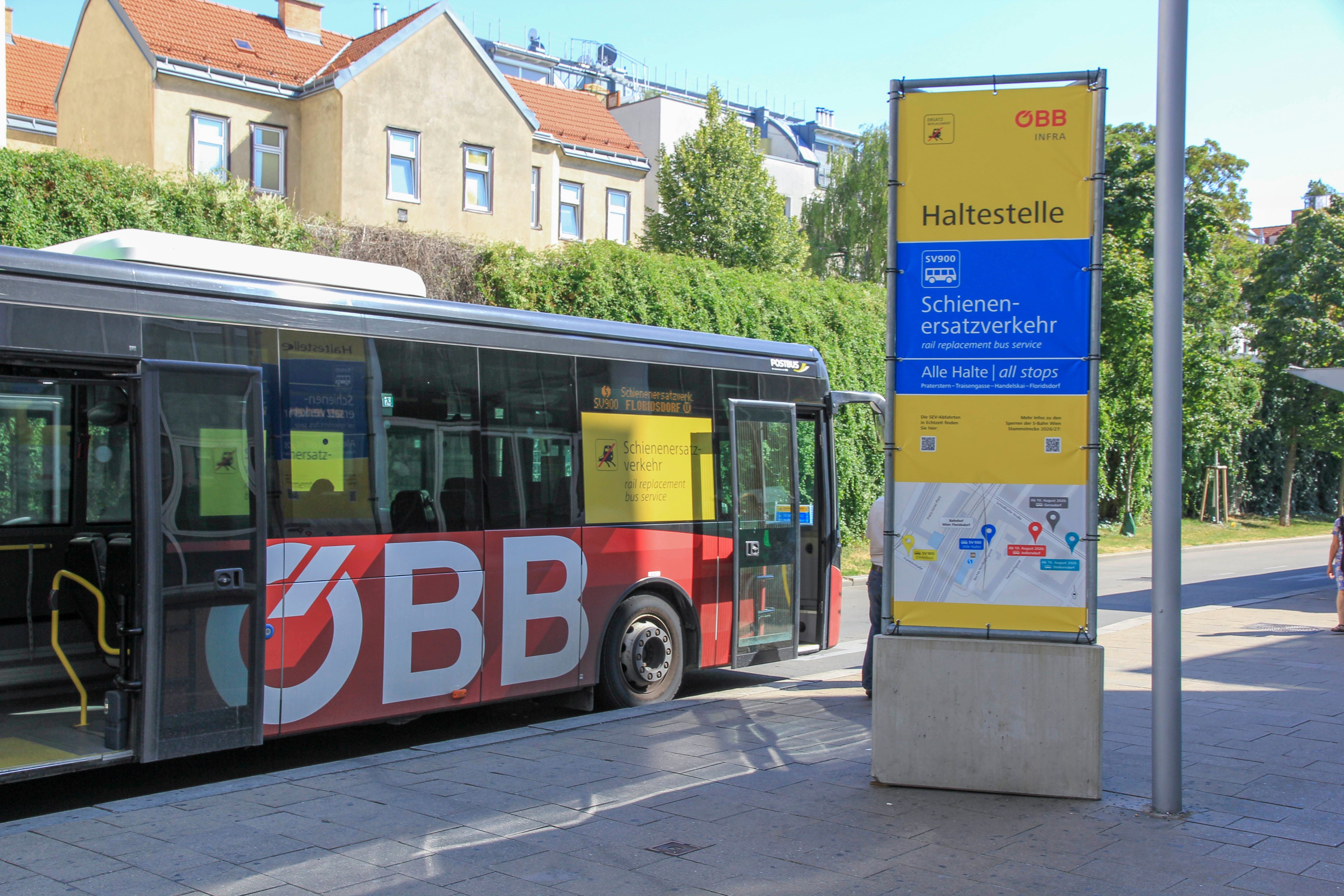 Ein ÖBB-Bus für Schienenersatzverkehr hält an einer gelben Haltestelle mit Fahrplanhinweis.