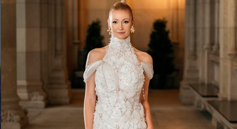 Frau in elegantem, glitzernden Brautkleid steht in einem prunkvollen Innenraum.
