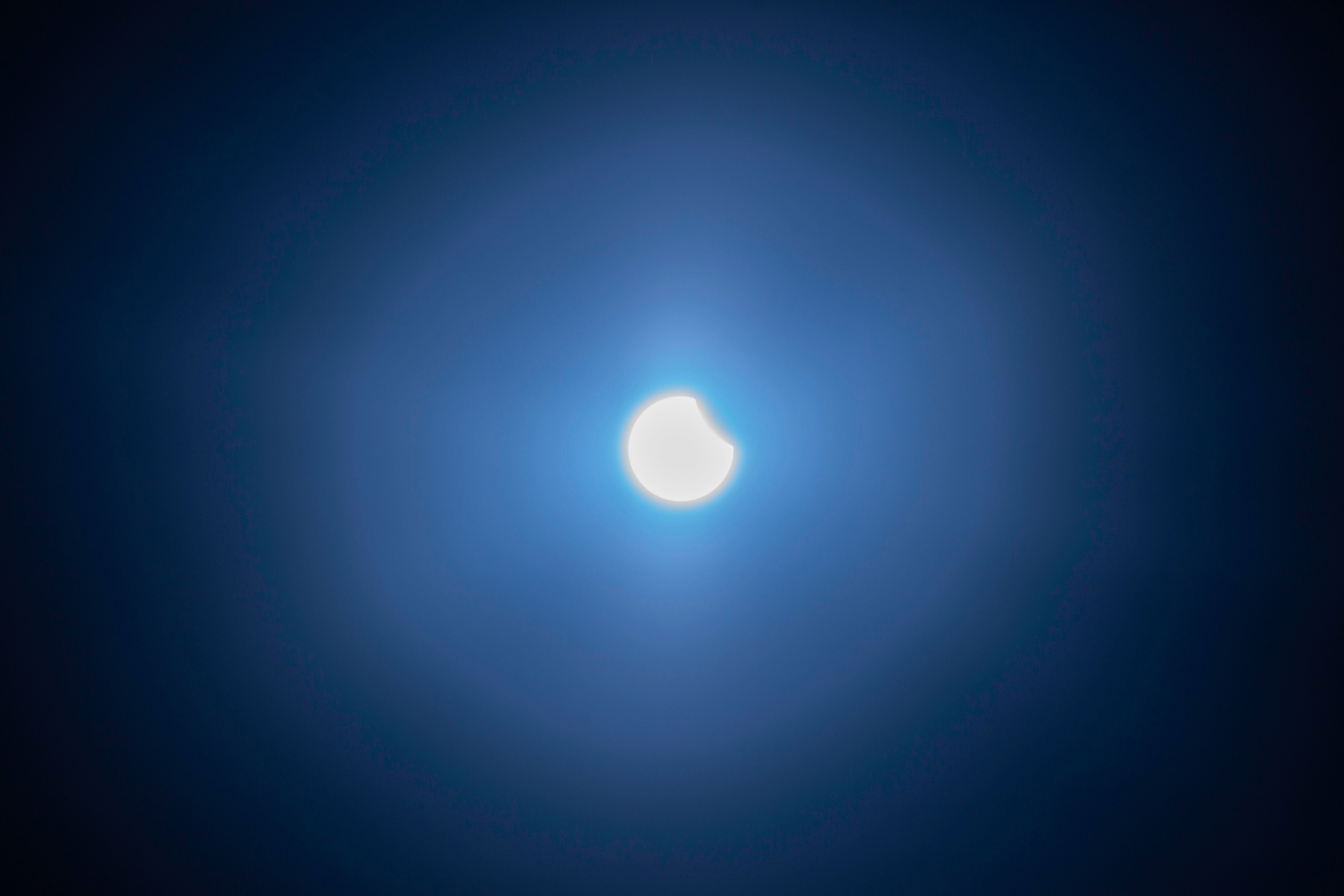Partielle Sonnenfinsternis am Himmel mit einem dunklen Bereich am Rand der Sonne.