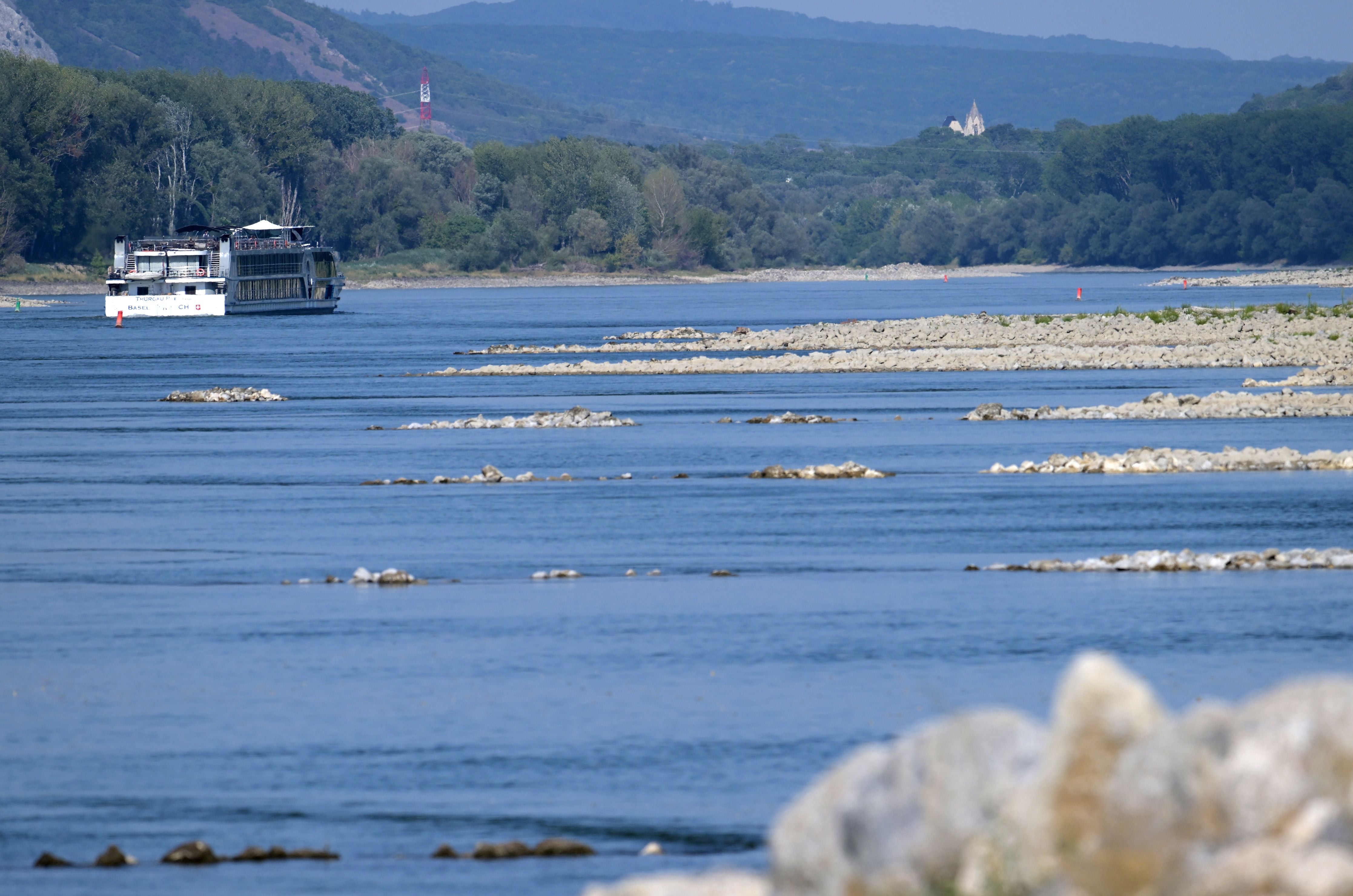 Ein Passagierschiff fährt auf der Donau mit sichtbaren Untiefen und freiliegenden Kiesbänken.