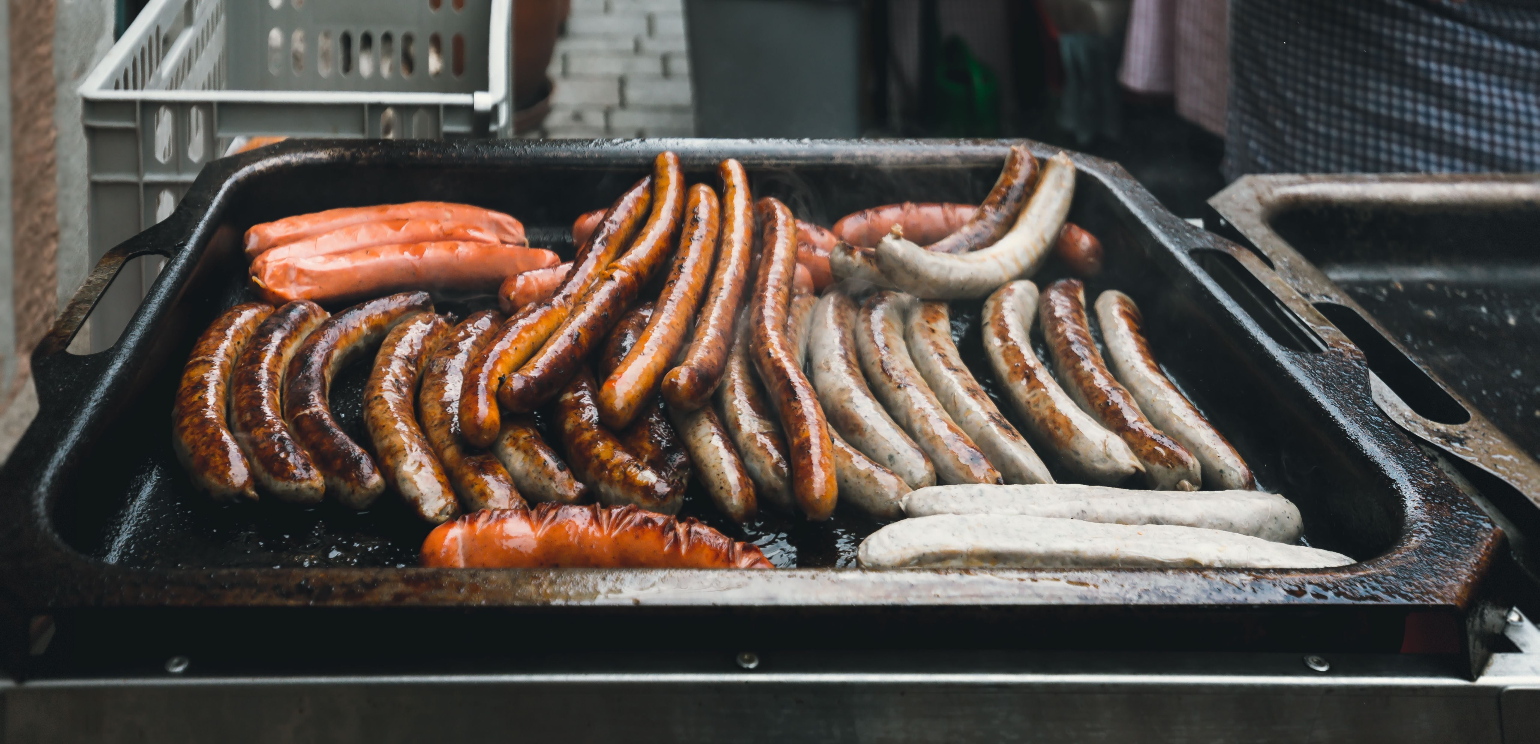 Verschiedene Bratwürste werden auf einem Grill in Rothenburg ob der Tauber gegrillt.
